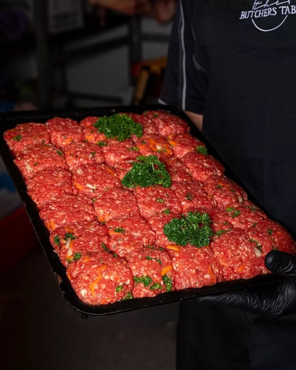 A tray of freshly prepared house-made rissoles garnished with parsley