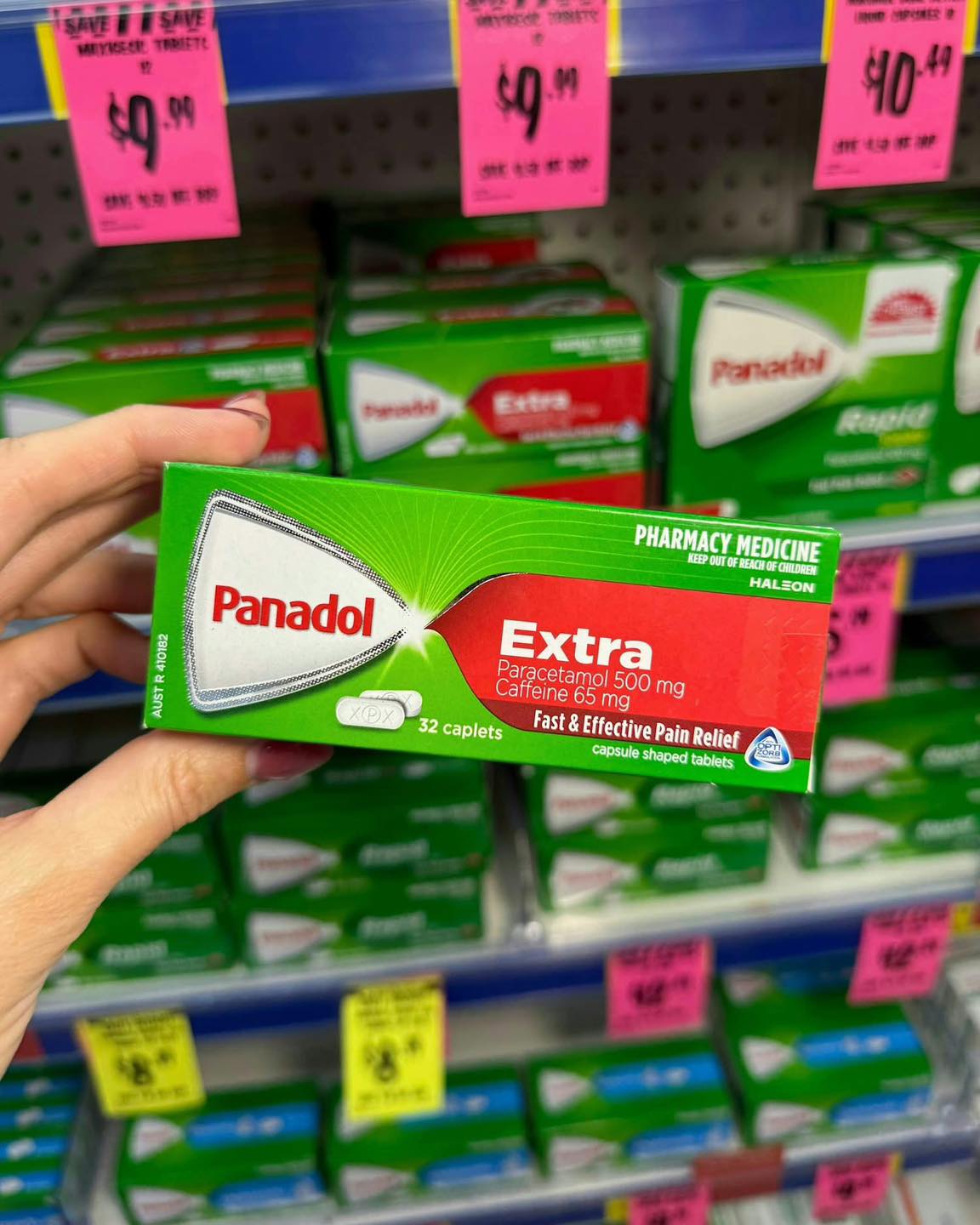 Box of Panadol Extra pain relief caplets in front of a shelf of Panadol products