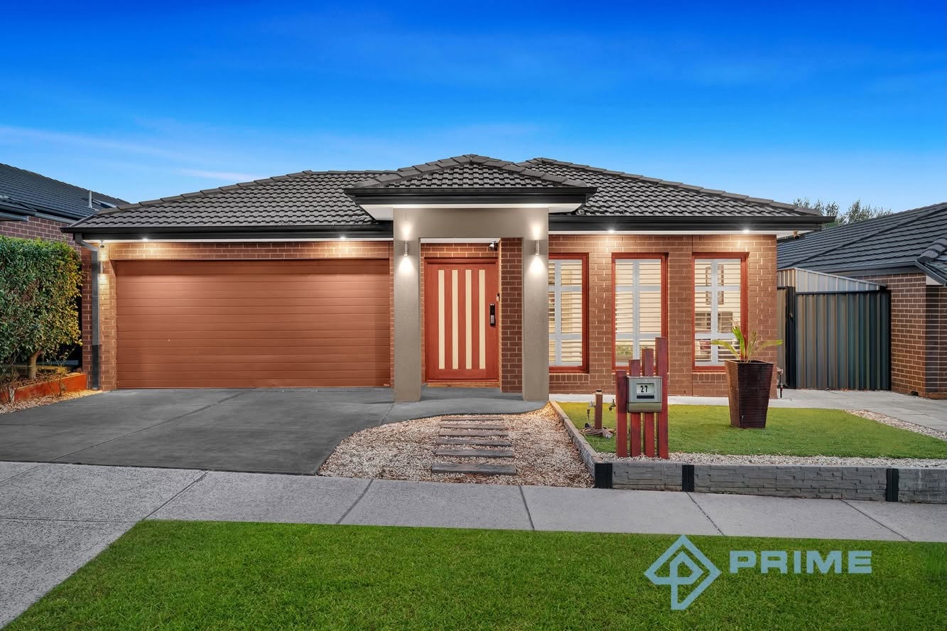 Modern brick home exterior at dusk with illuminated entrance and manicured lawn — Prime Estate Agency