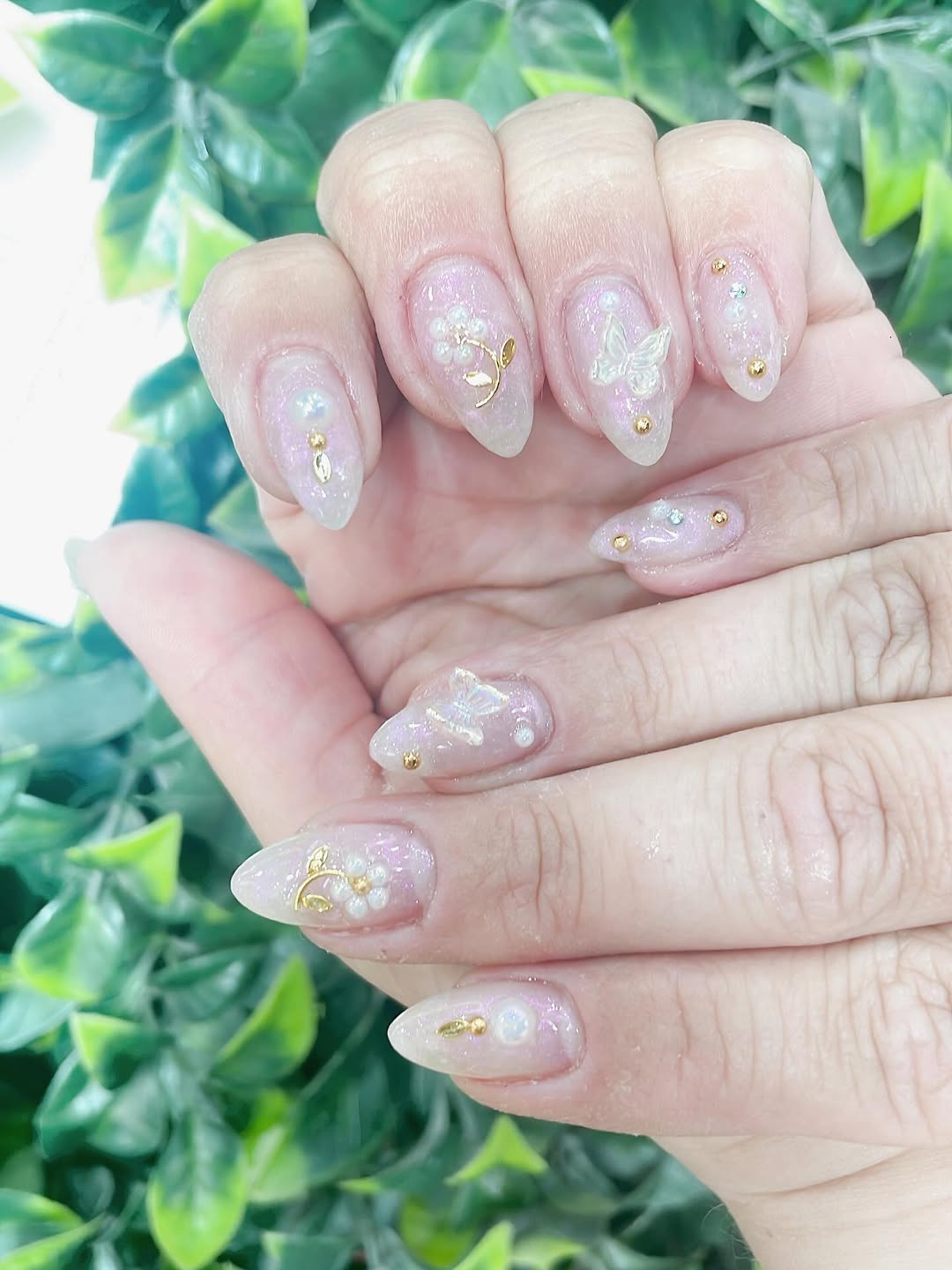 Iridescent pearl nail art with butterfly and gold accents