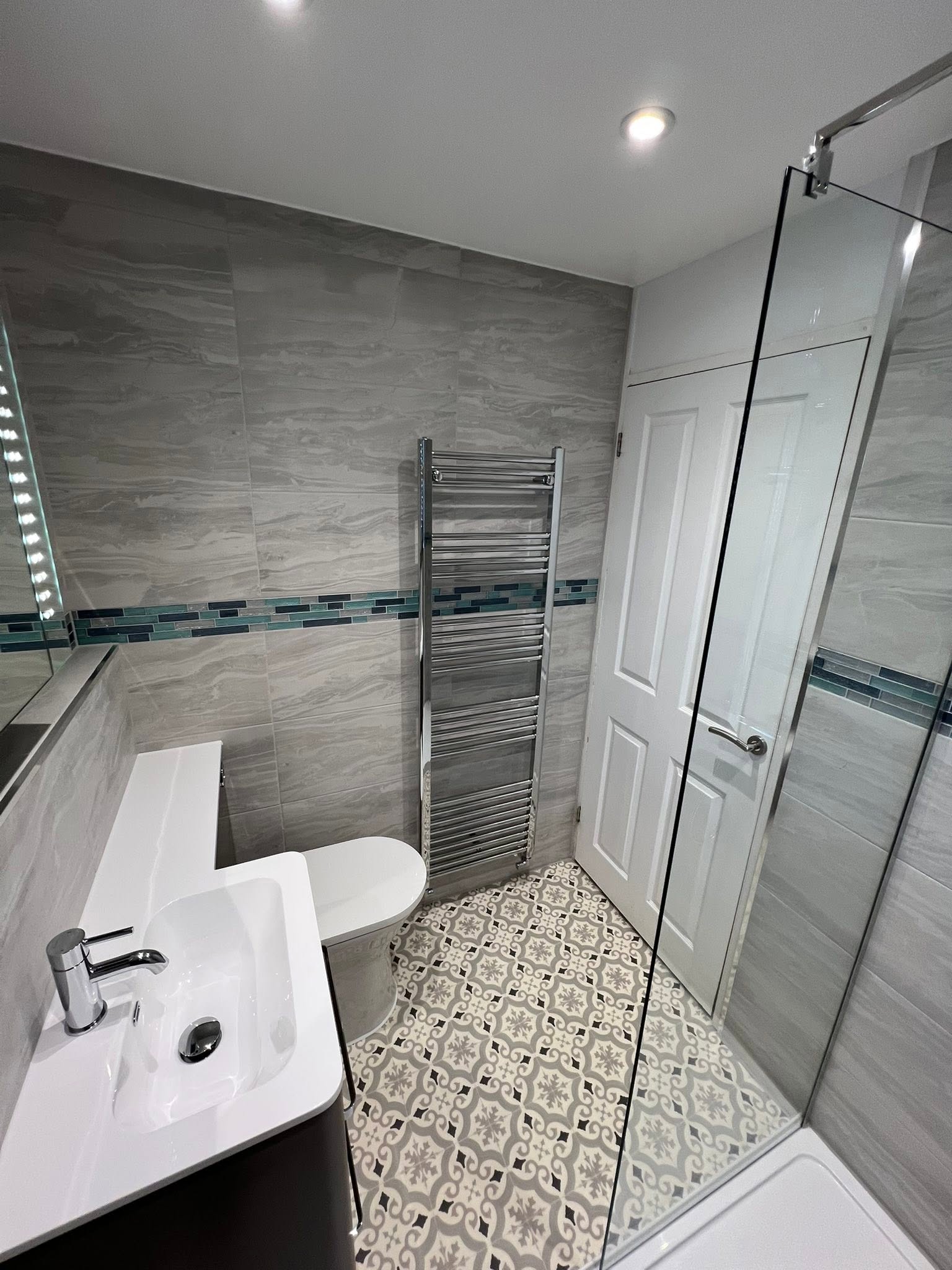 Modern bathroom with marble-look wall tiles and glass shower screen