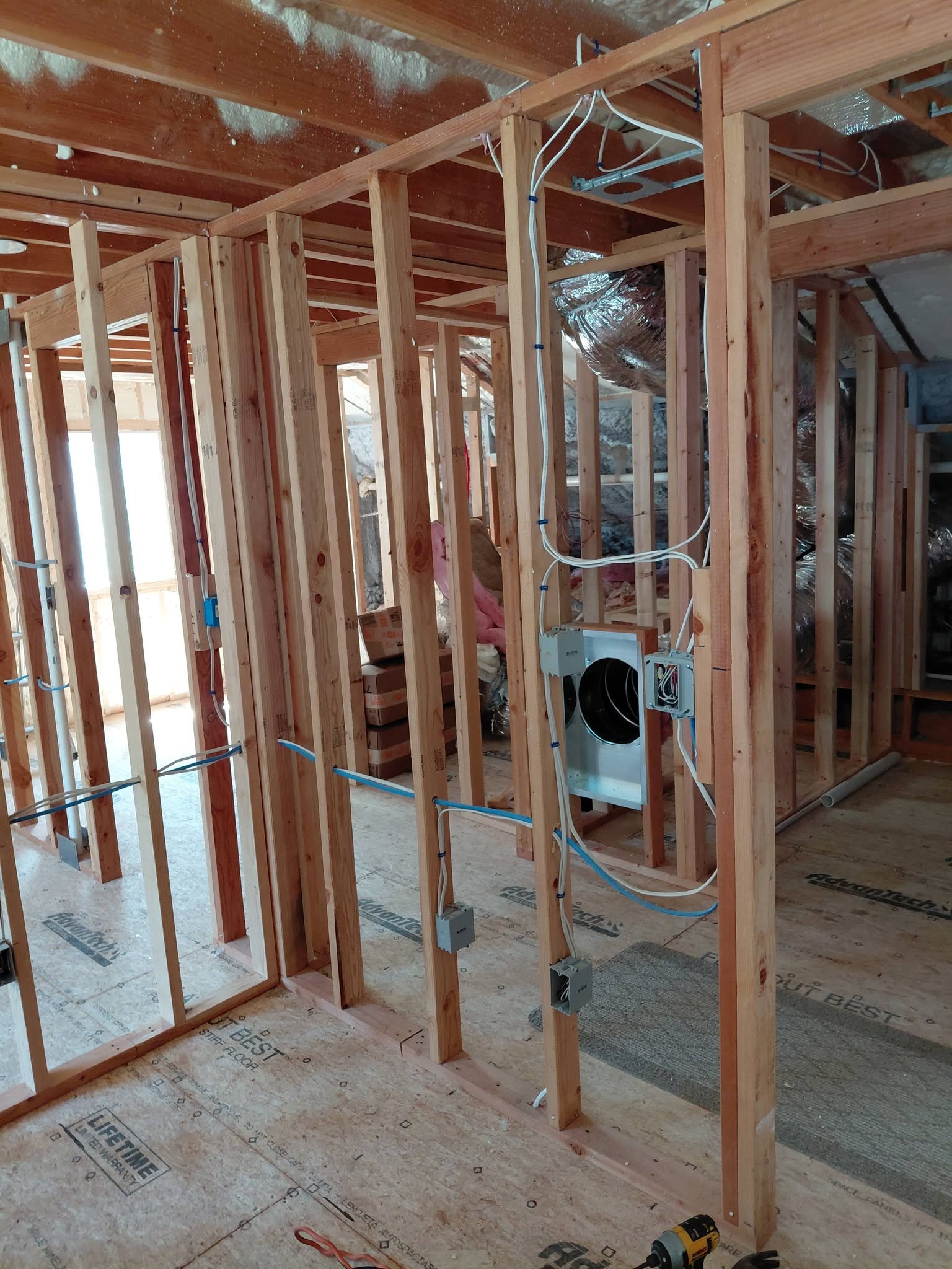 Electrical wiring and conduit runs inside timber framing during construction