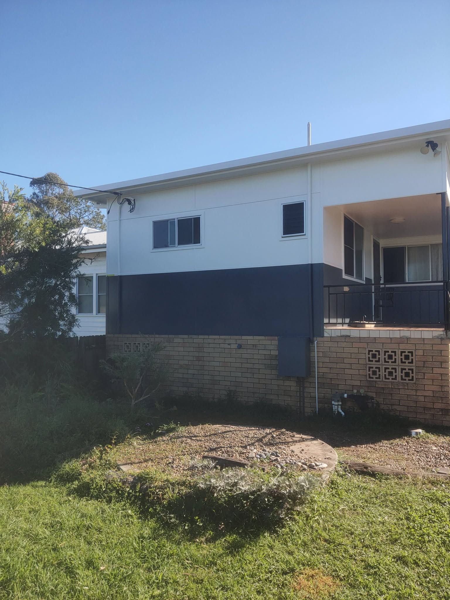Freshly painted house exterior — white and navy two-tone finish by Refresh King