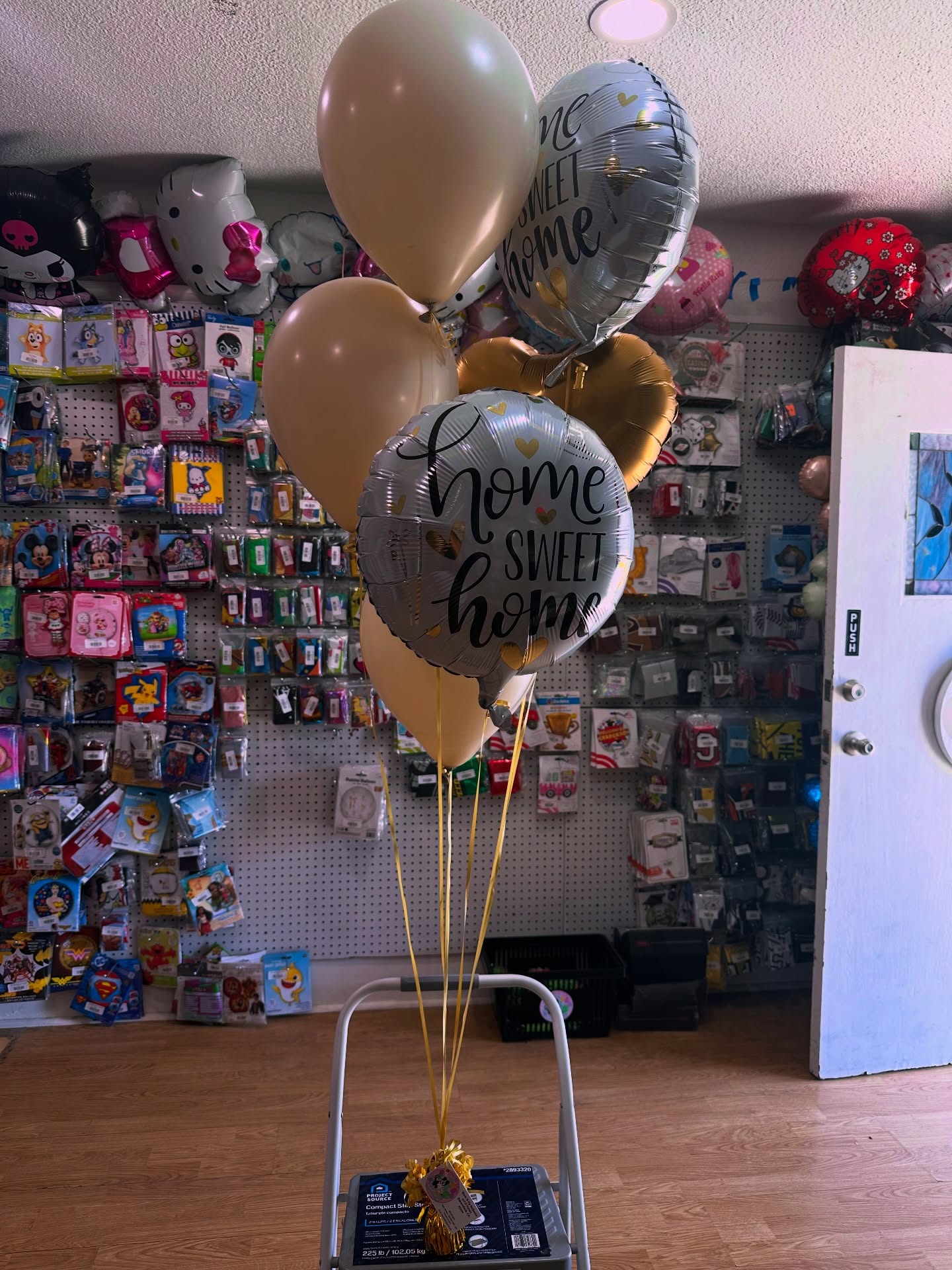A bouquet of gold, cream and silver 'home sweet home' balloons on display