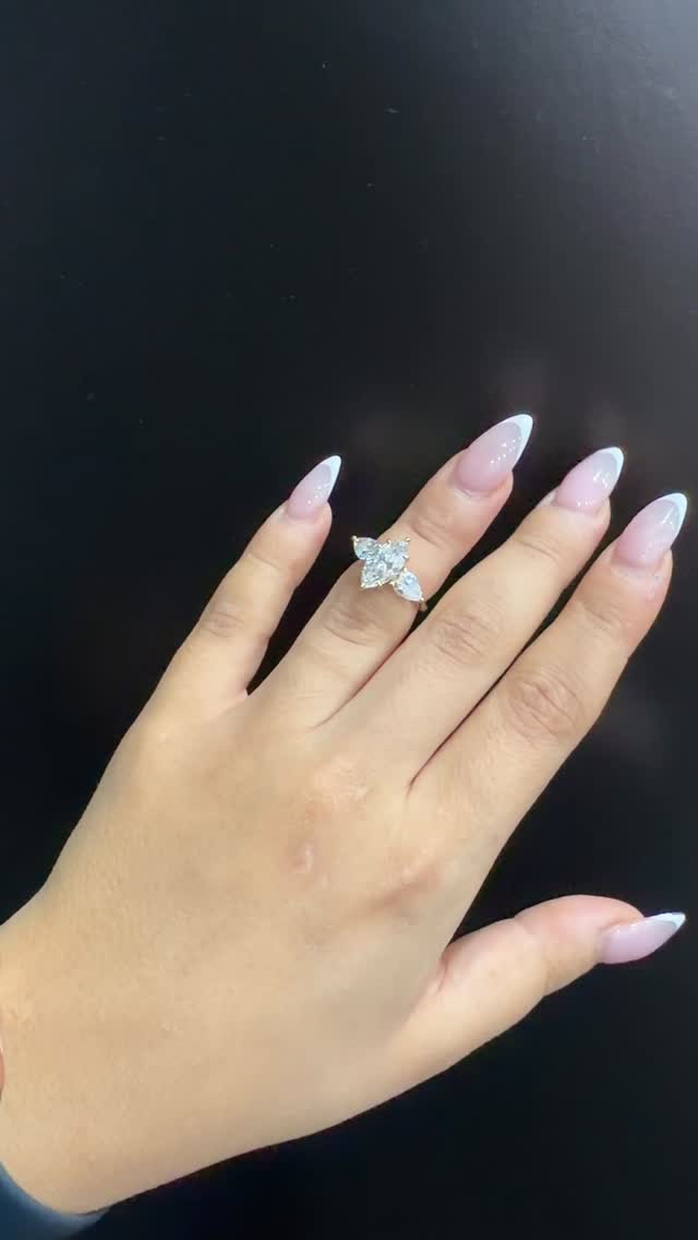 Three-stone marquise diamond ring on dark background