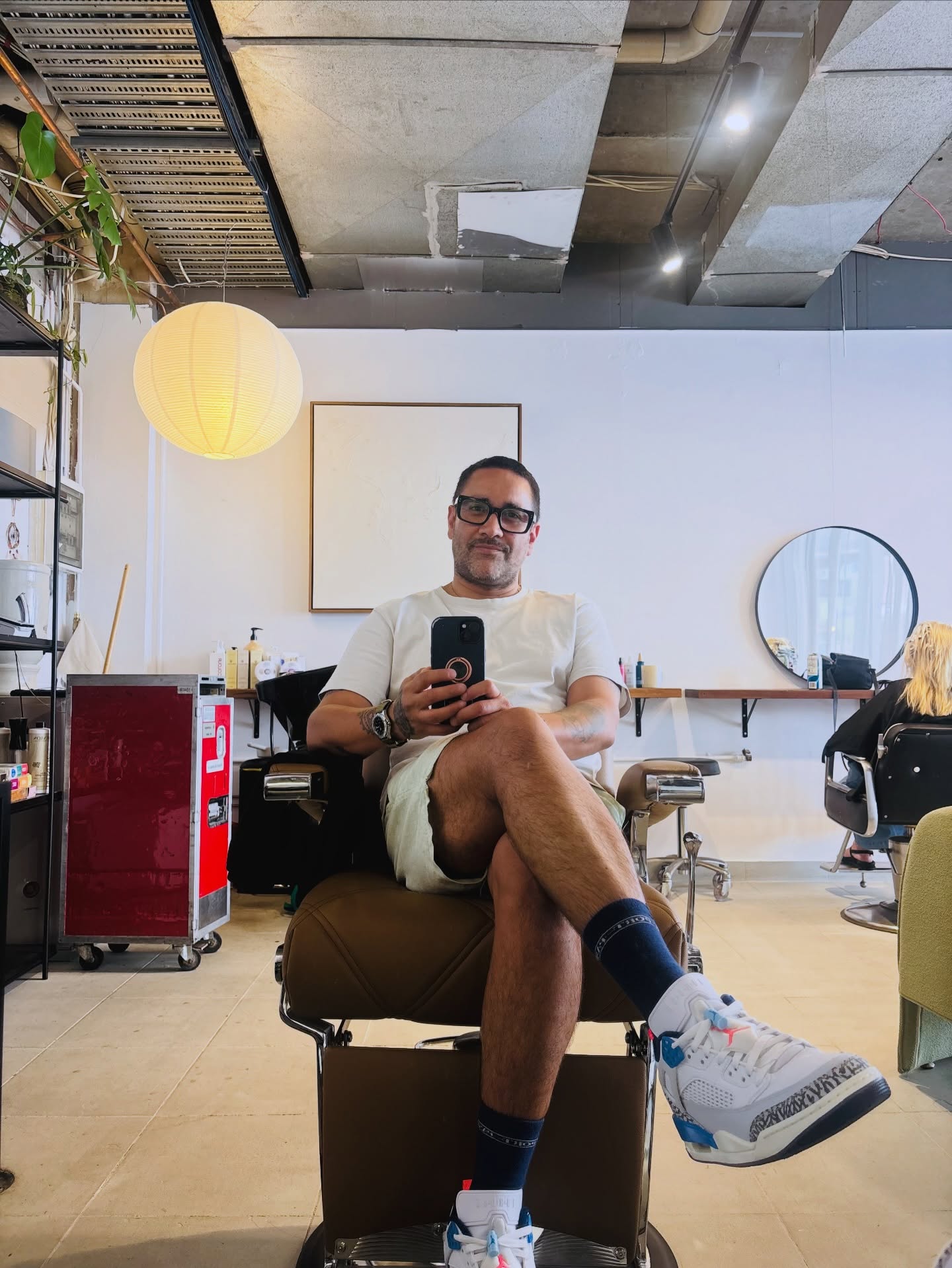 Inside the salon with a barber chair, round mirror and paper lantern
