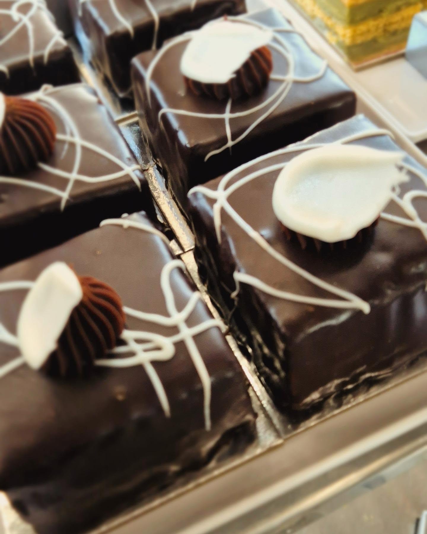 Freshly baked chocolate slices topped with chocolate curls, on display at Schwabs Galley