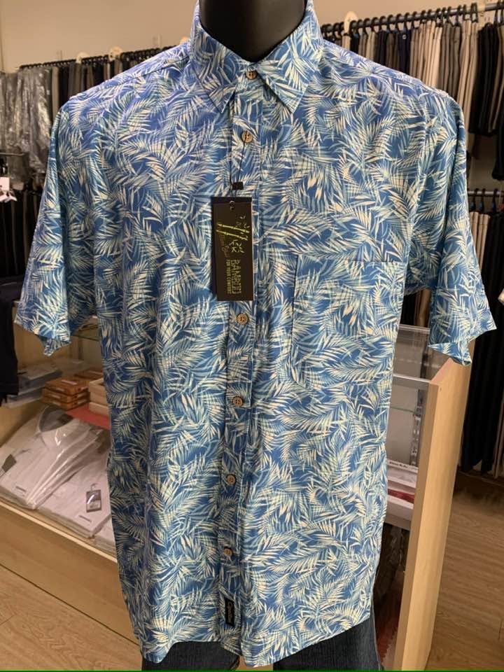 Short-sleeve shirt with a blue and cream palm leaf print on a display mannequin