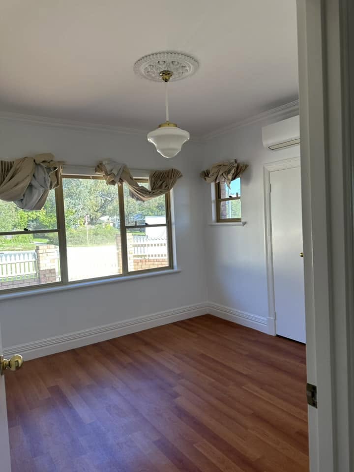 Freshly painted interior room with period pendant light and timber floors — Bendigo home