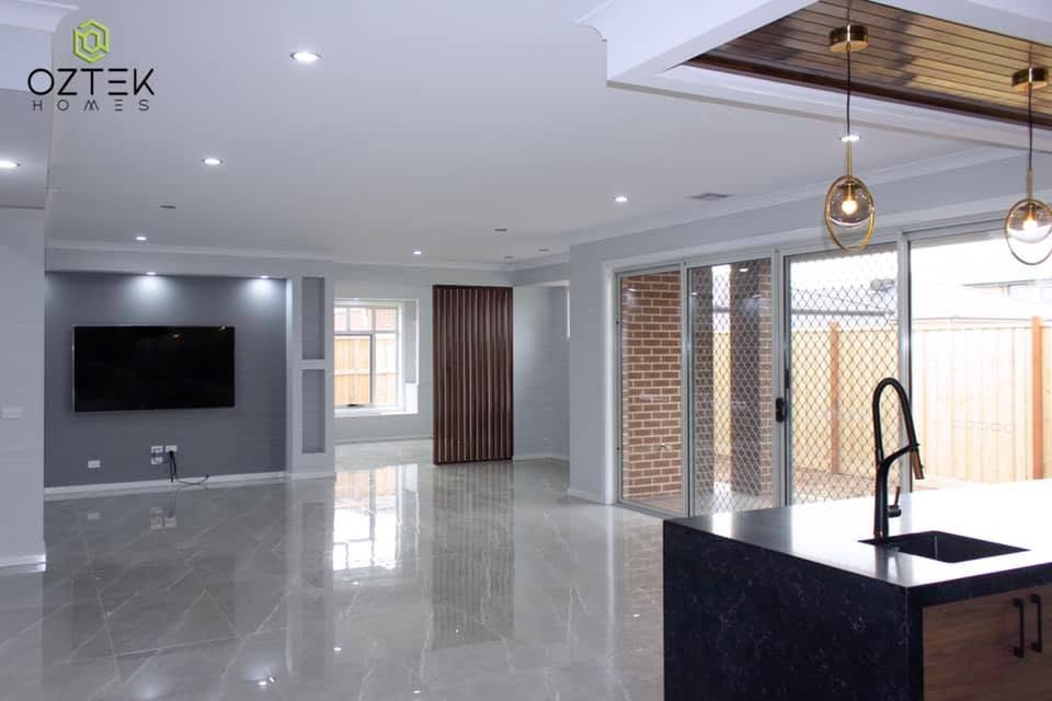 Spacious open-plan living and kitchen area with polished marble floors and gold pendant lights