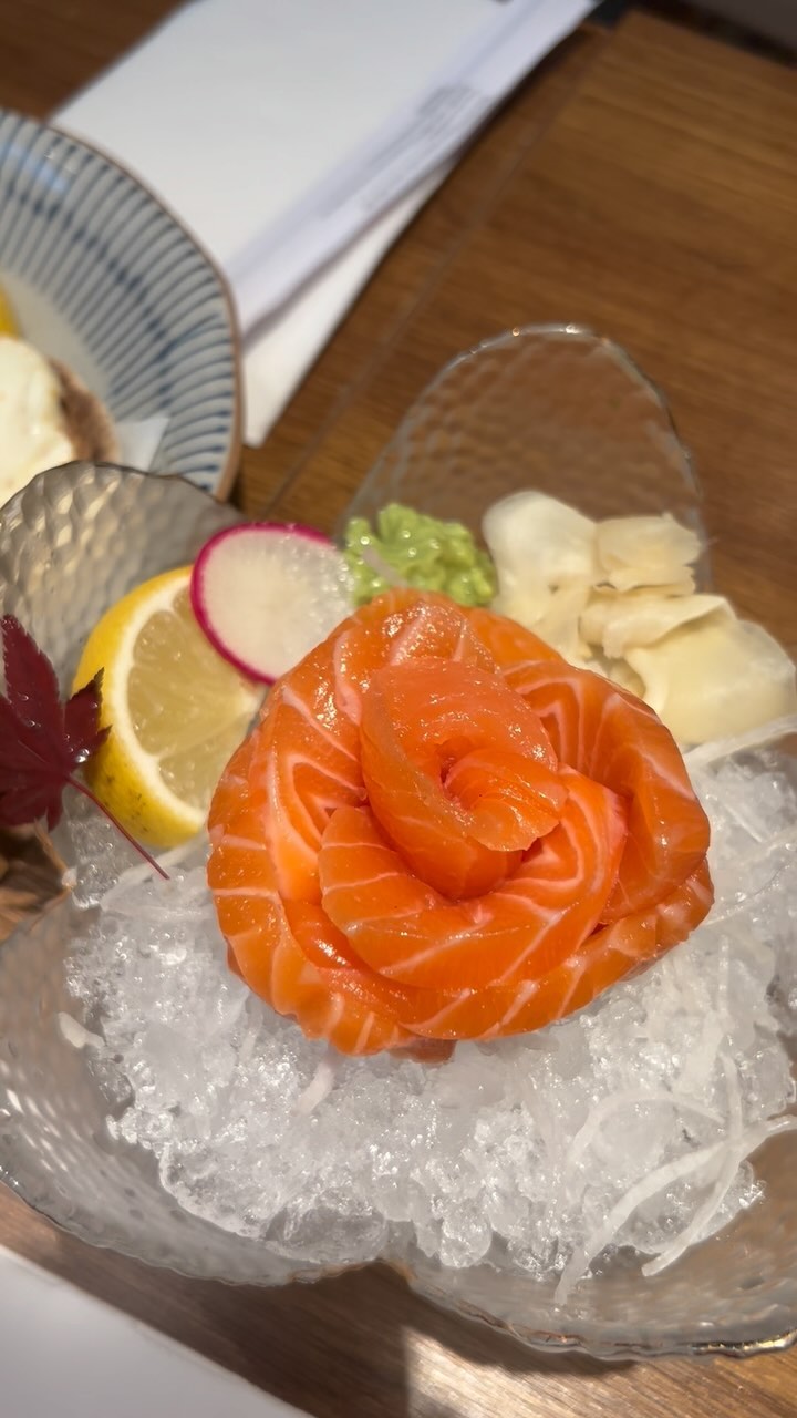 A delicate rose-shaped salmon sashimi arrangement served with wasabi, pickled ginger and citrus at UMAYA World Square