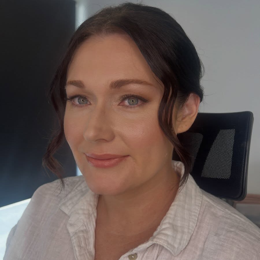 Client with beautifully styled dark wavy hair and warm glowing makeup