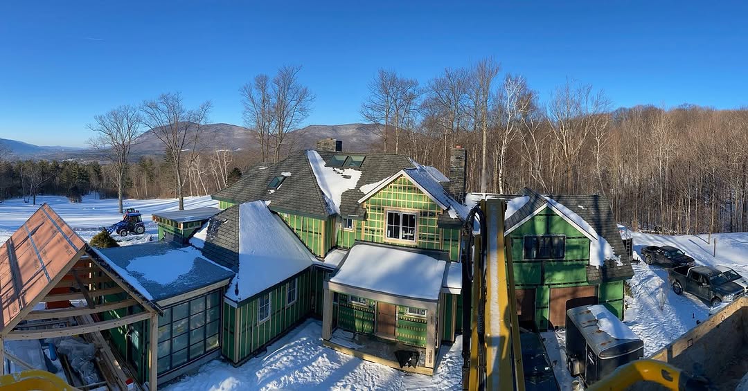 Aerial view of large luxury home under construction in winter