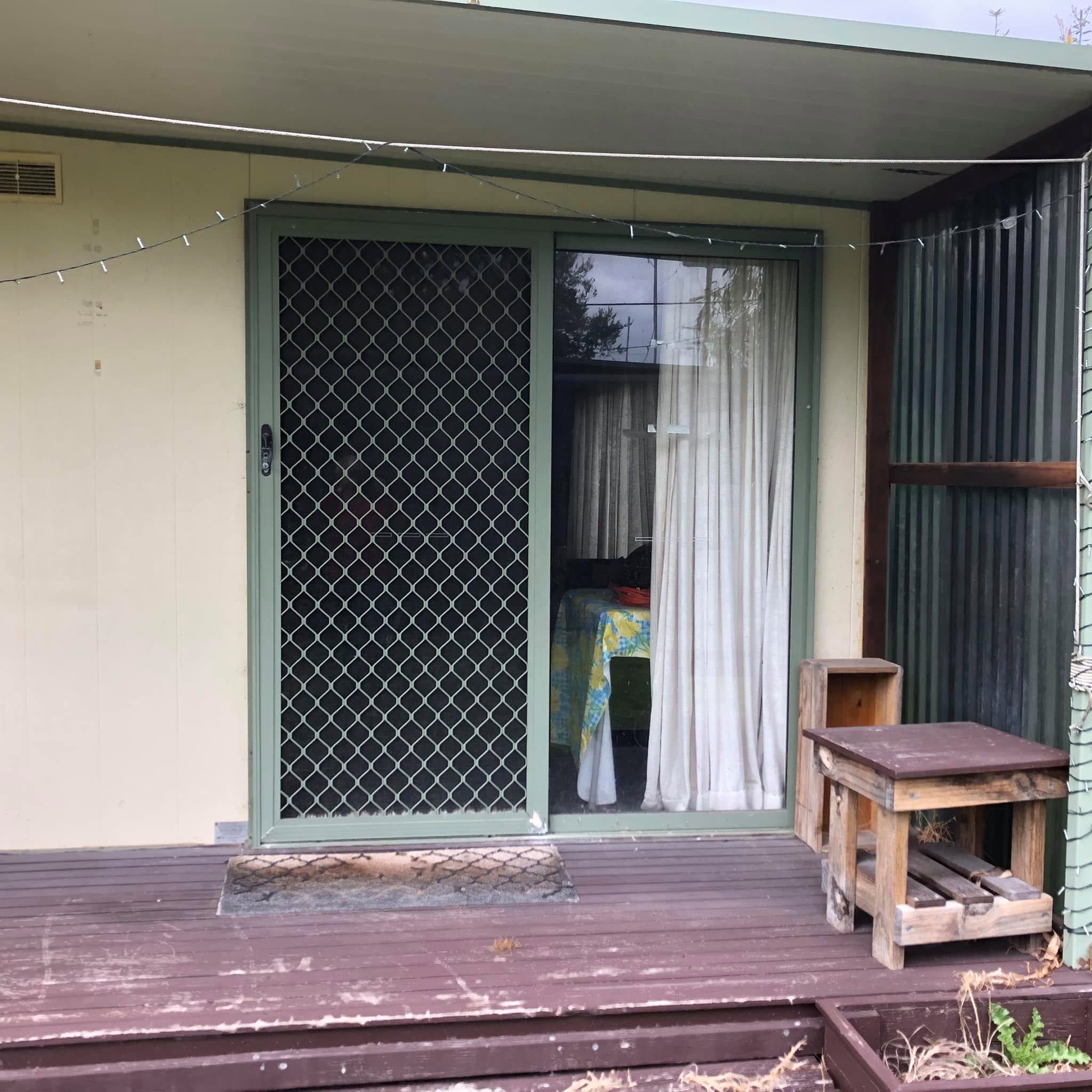 Short-stay accommodation cabin with timber deck at Sandy Point Holiday Park