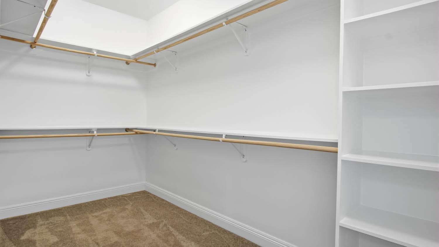 A spacious walk-in wardrobe with built-in shelving and hanging rails