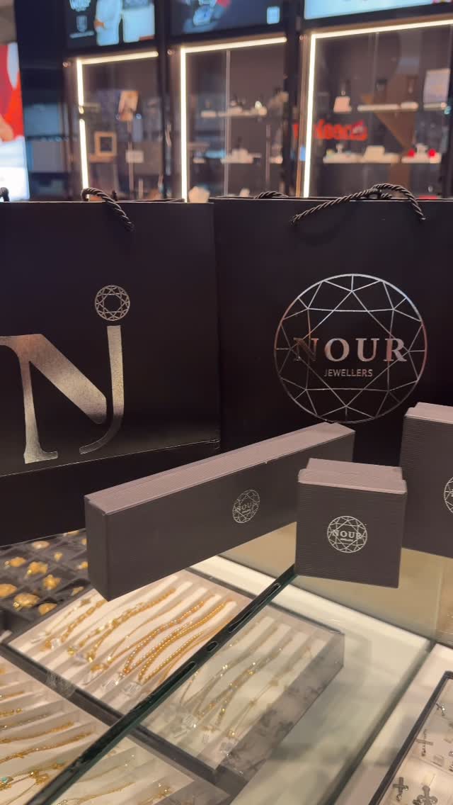 Nour Jewellers branded shopping bags and gift boxes displayed over glass jewellery counter