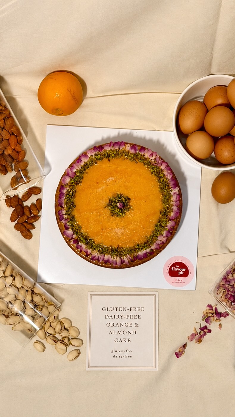 Gluten-free, dairy-free orange and almond cake decorated with dried rose petals and crushed pistachio
