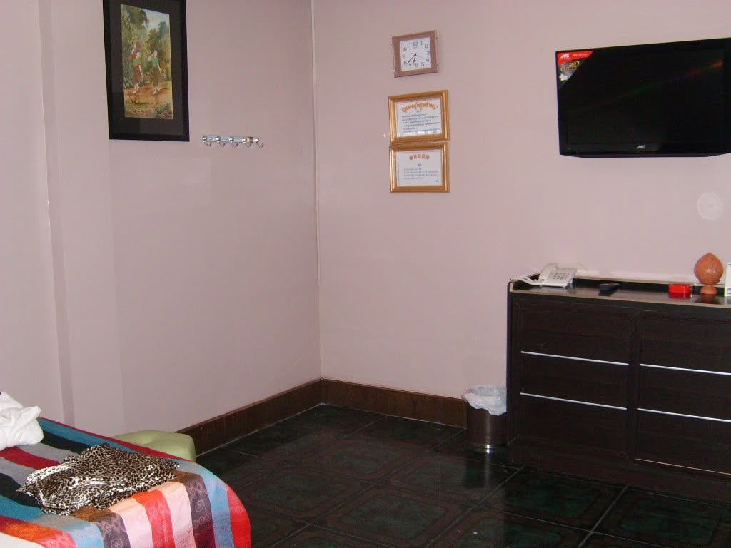 Calm private massage treatment room with soft lighting and framed certificates