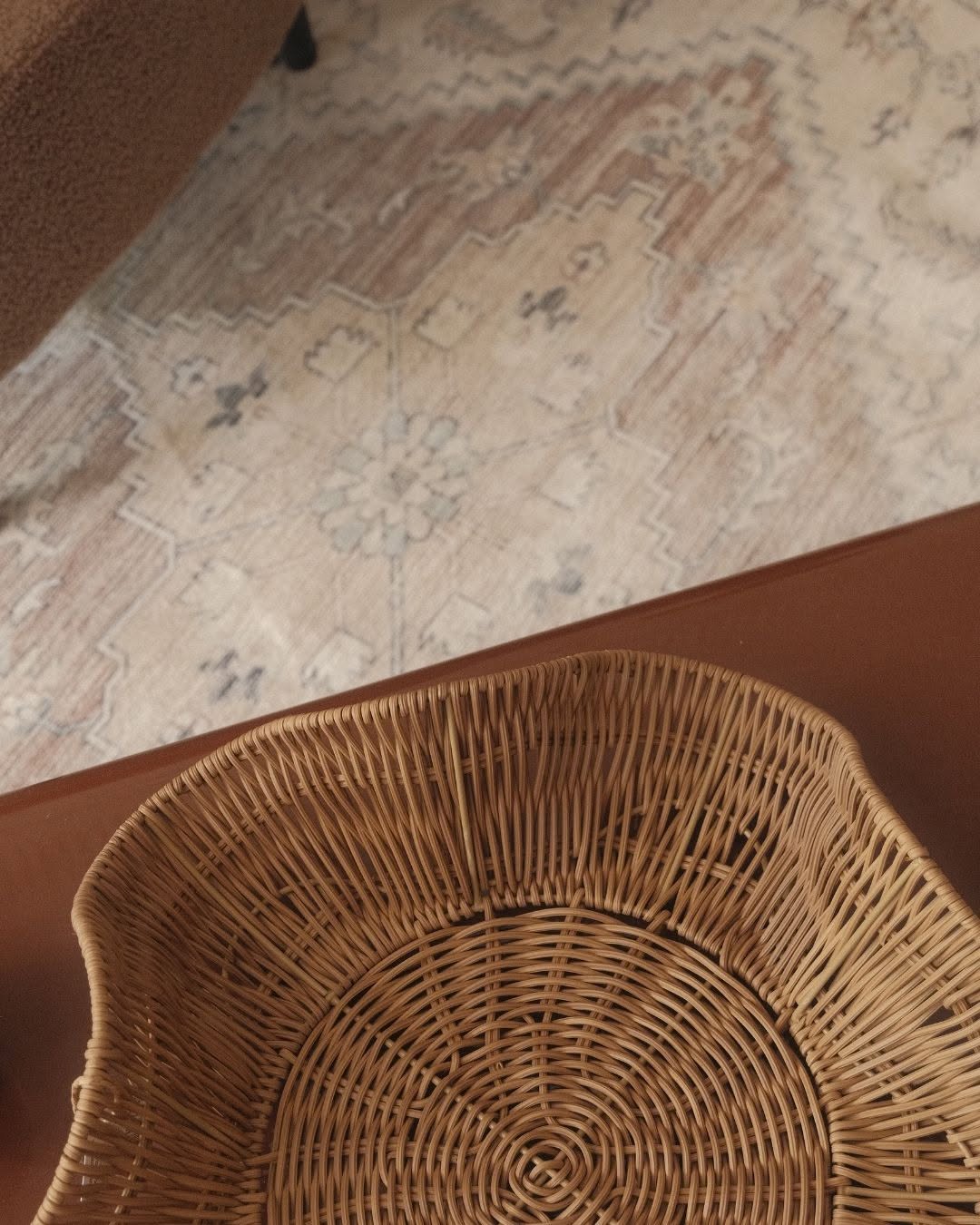 Wicker rattan basket on a patterned rug, representing homewares and storage products