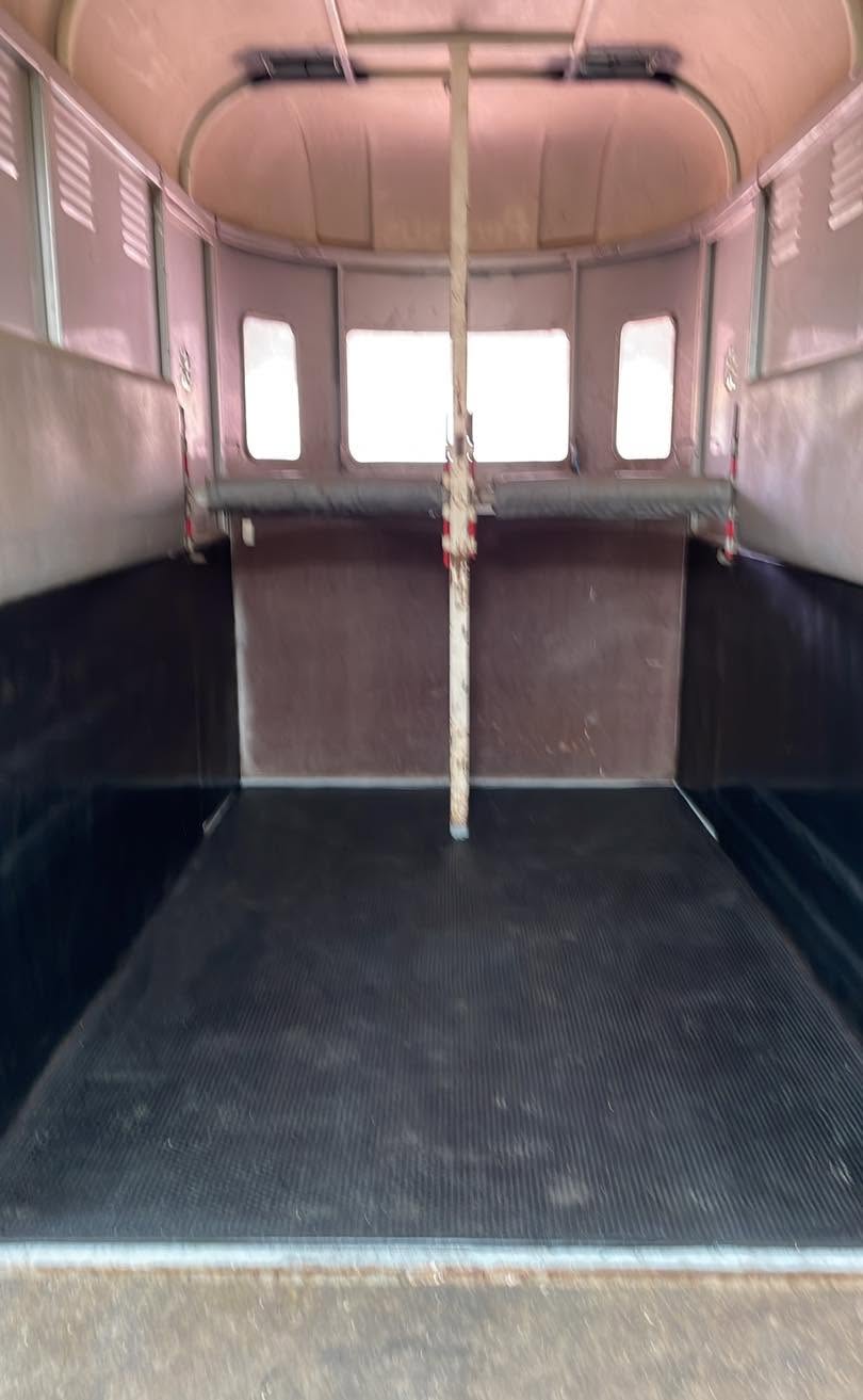 Inside of an older horse float showing rubber matting and divider