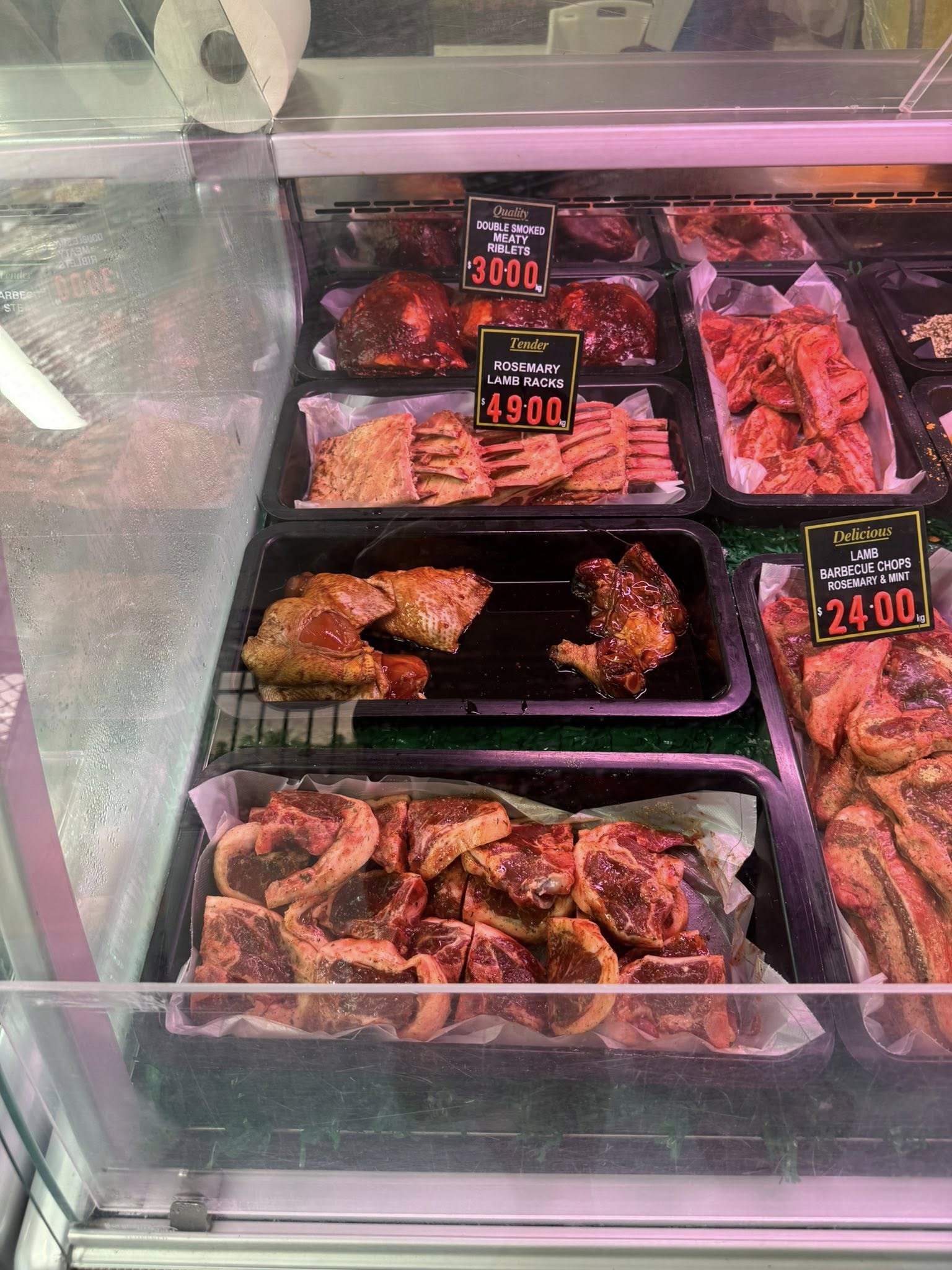 Full display case showing rosemary lamb racks, riblets and barbecue lamb chops at Ti Bulk Meats