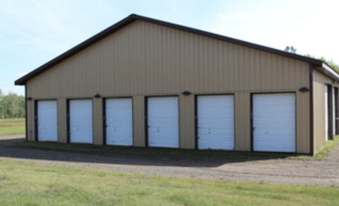Corner angle of tan and brown storage building with dark trim and light posts