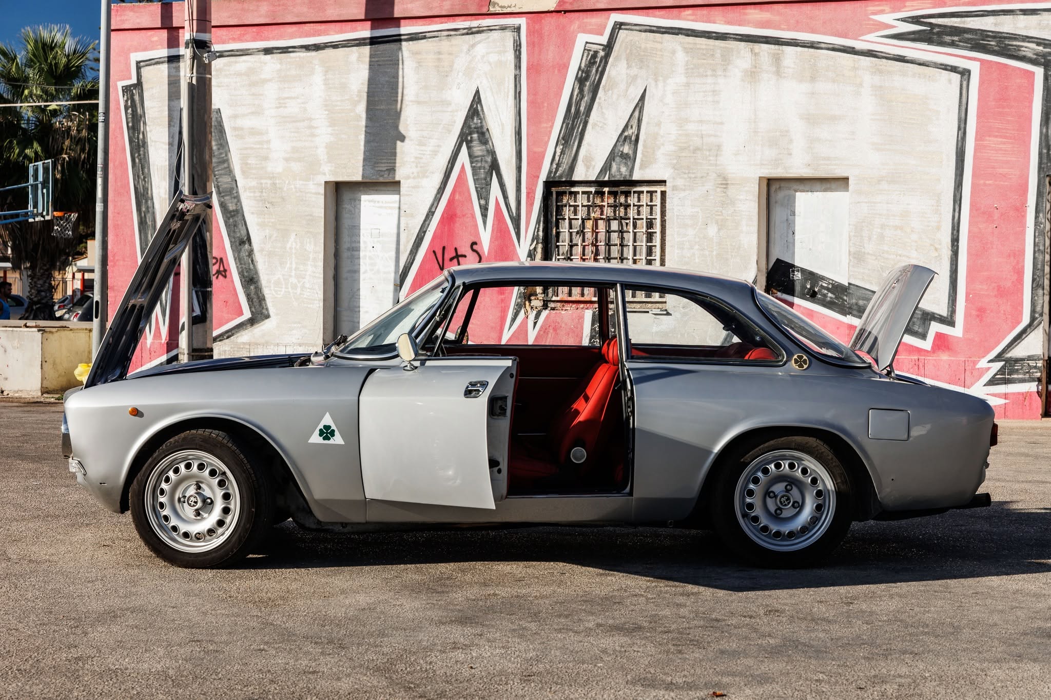 Silver Alfa Romeo GT with open door showing red leather interior restoration