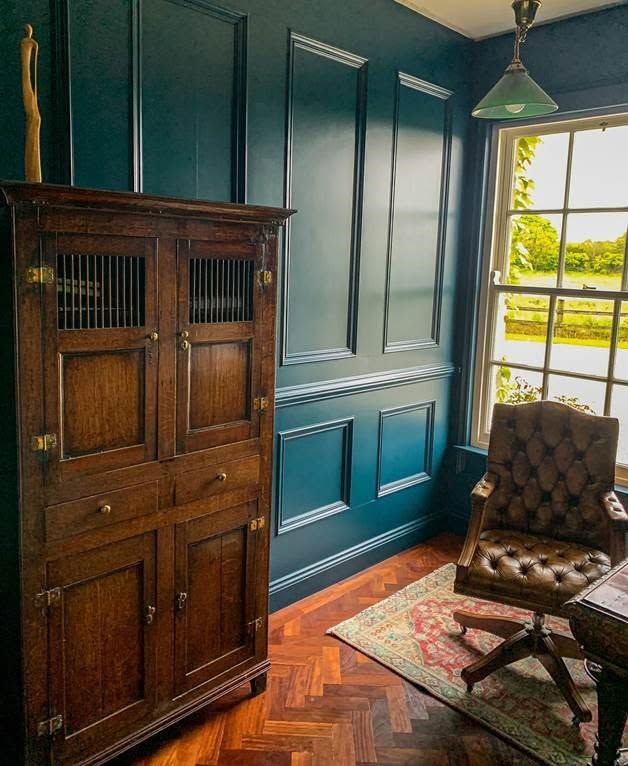 Vintage timber cabinet and wrought-iron lantern in a heritage-style room — a showcase of salvaged period furniture
