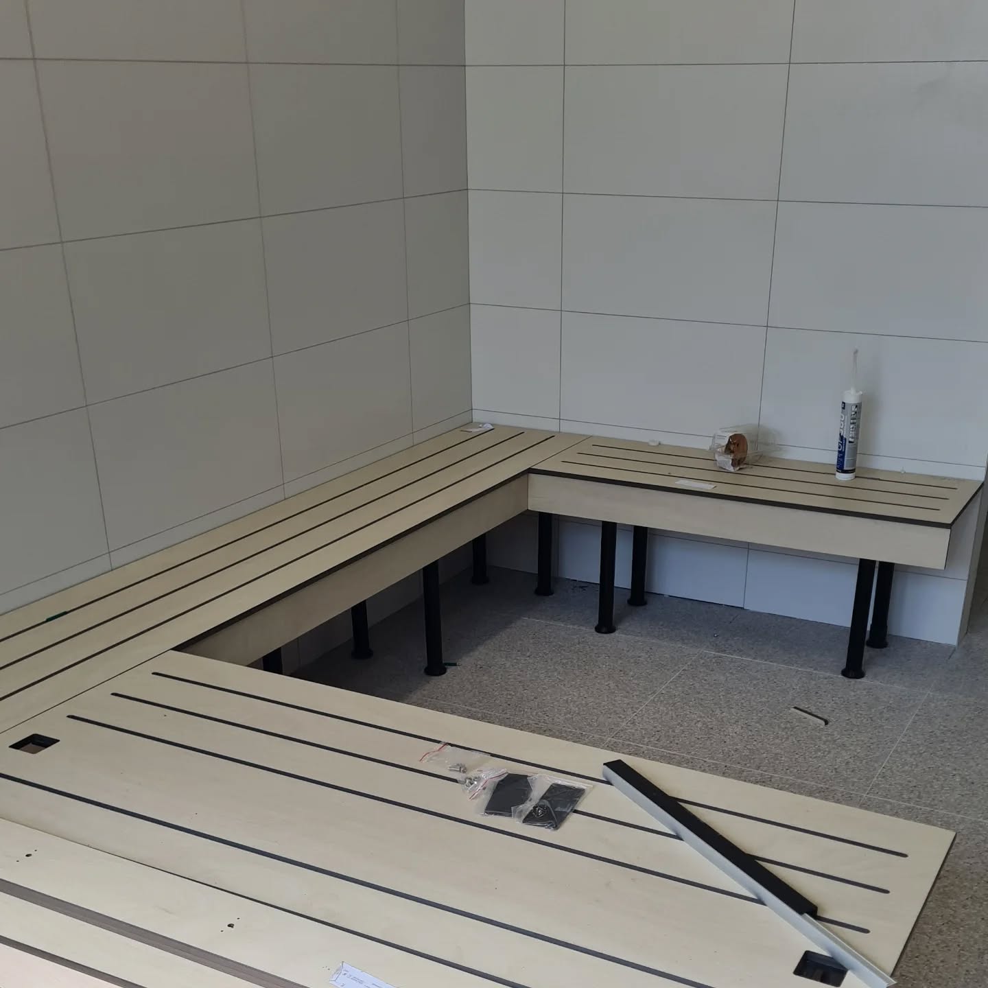 Custom bench seating being installed in a tiled room — A2Z Build shopfitting work