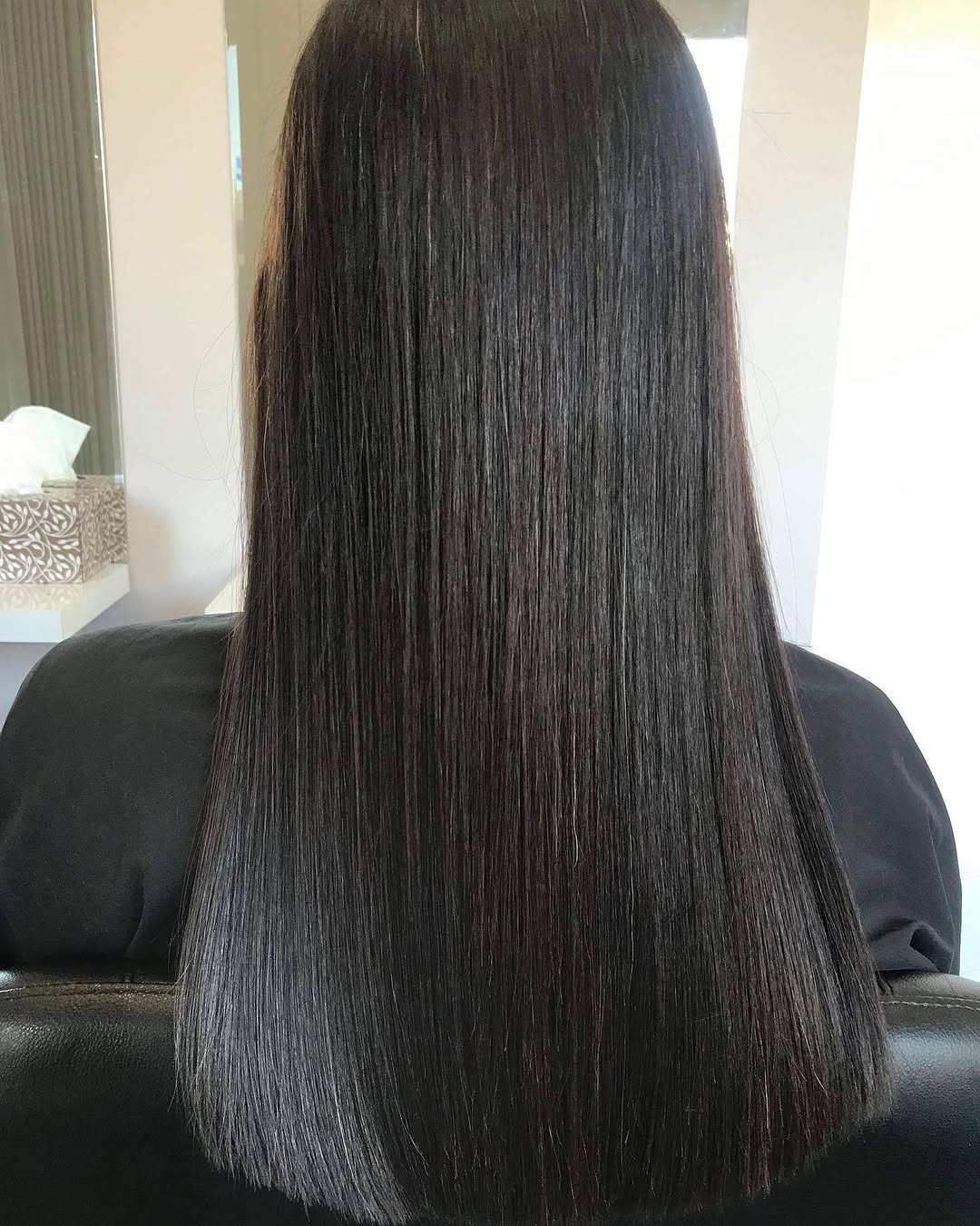 Sleek, shiny dark hair result from a keratin treatment at NAIDAS HAIRSALON