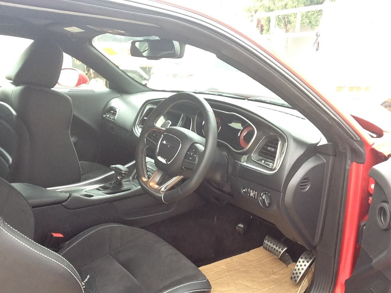 Hellcat badge on the door of a red Dodge Challenger — Custom Vehicle Services detail work