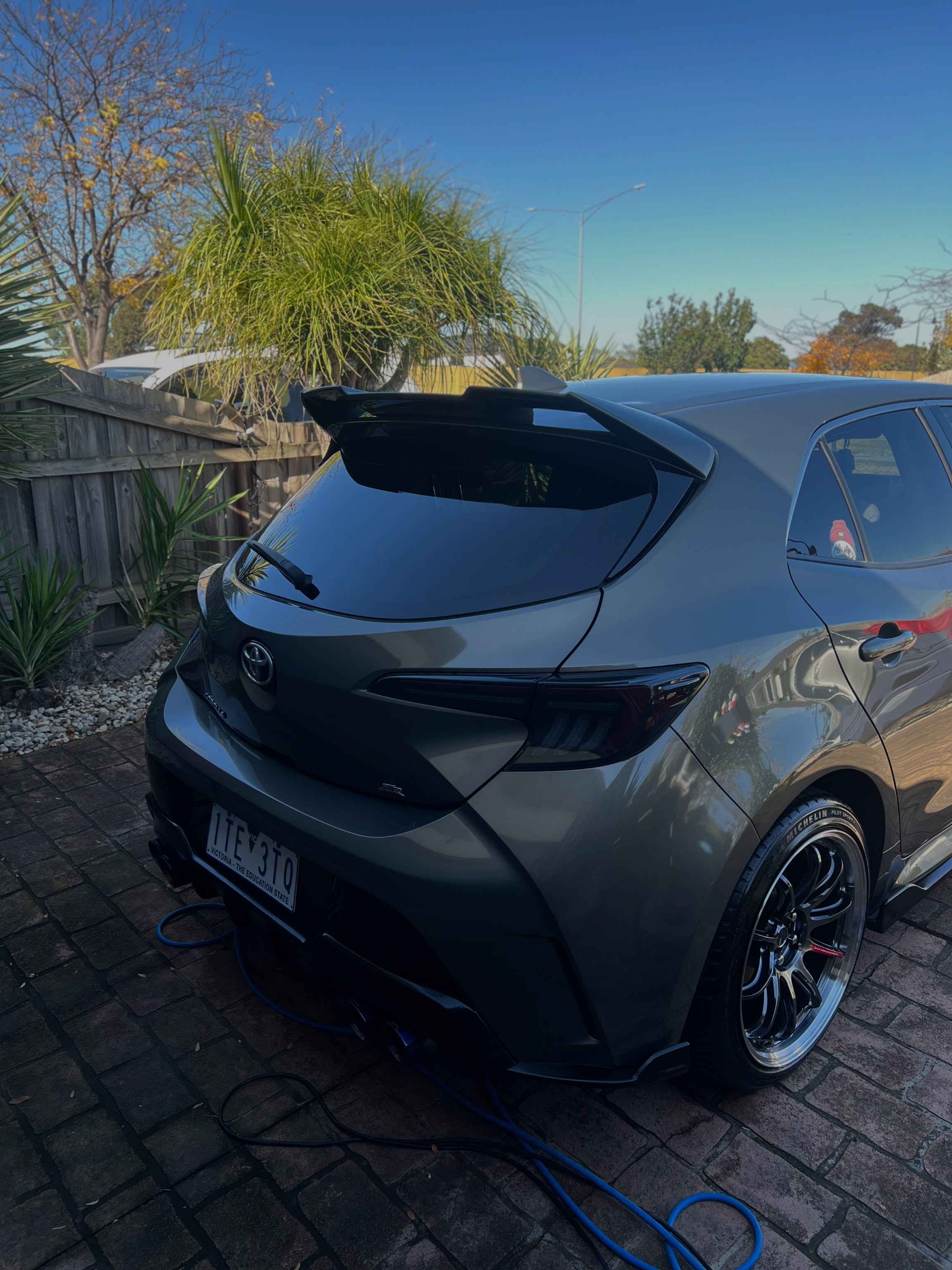 Detailed grey Toyota Corolla hatchback with a spoiler, glossy paint finish
