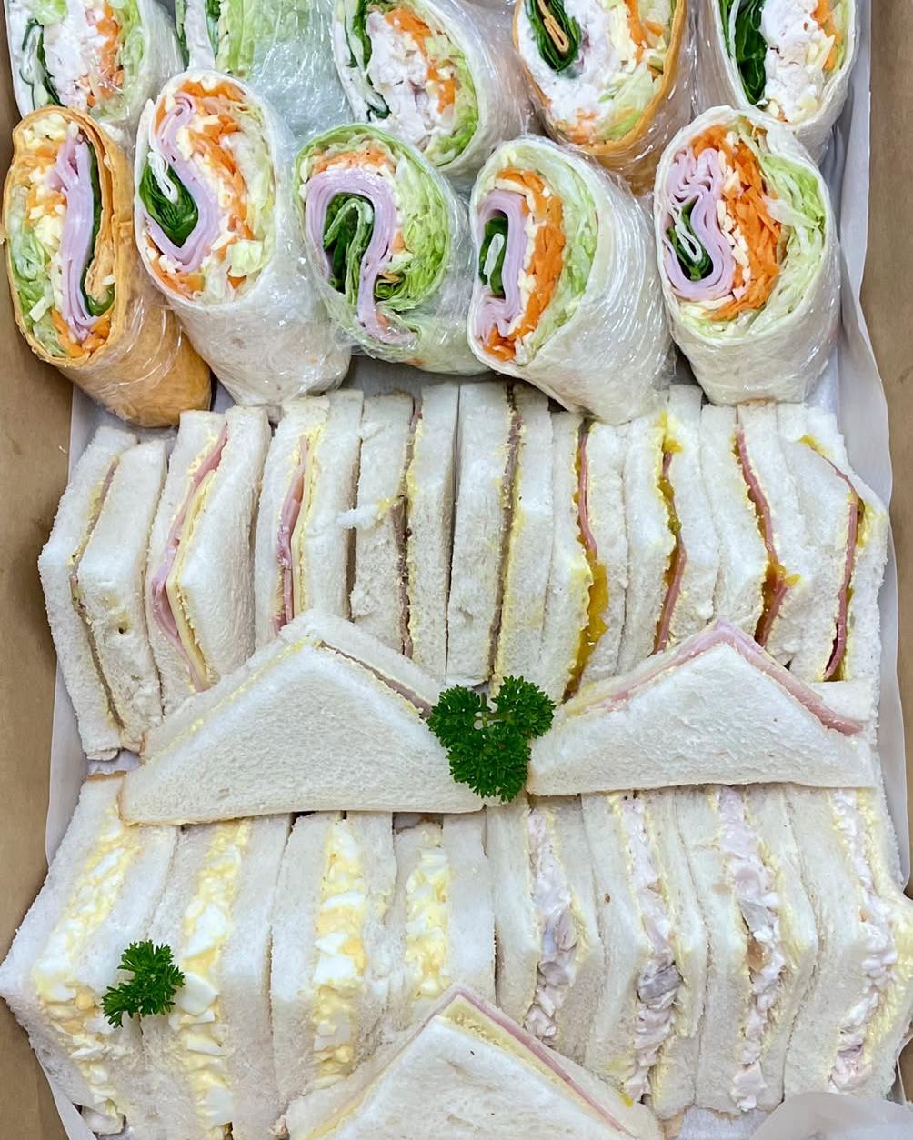 Beautifully presented assorted sandwich and wrap platter in a catering box