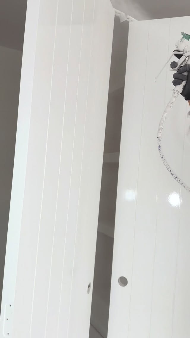 Spray painting interior panels — professional painting equipment in use
