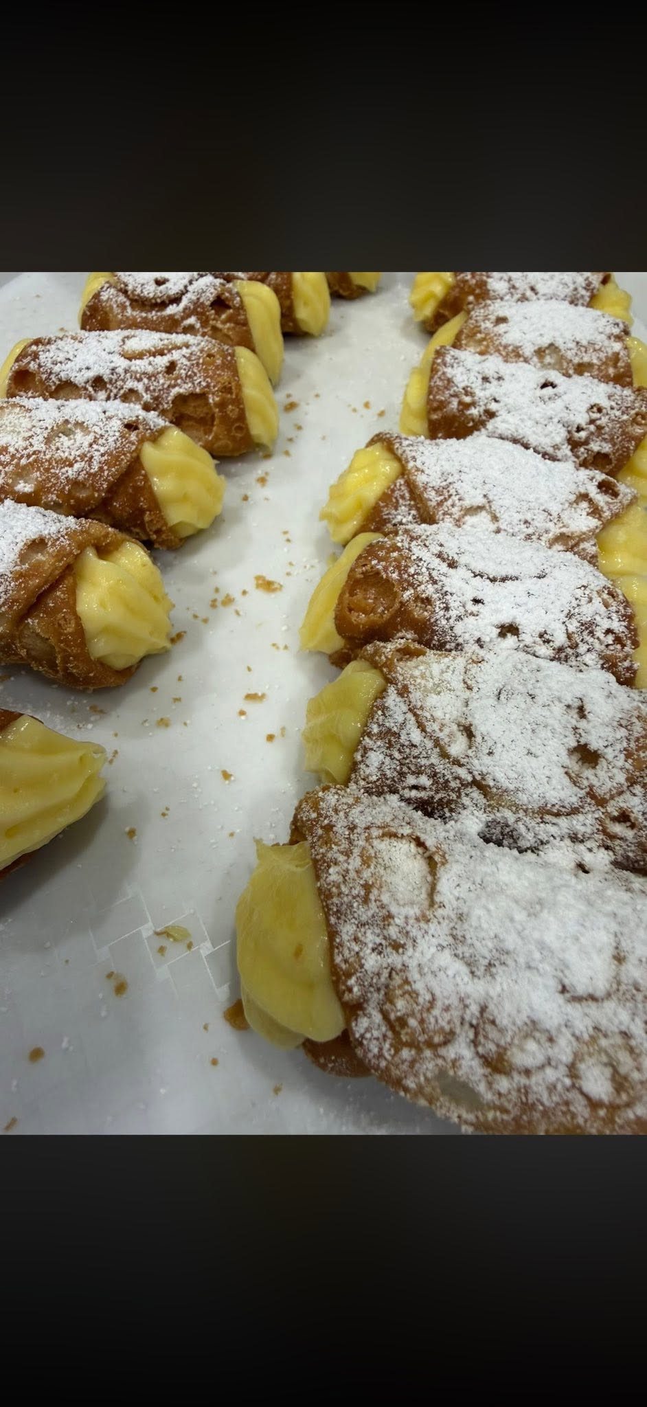 Fresh pistachio ricotta cannoli arranged on a white serving plate