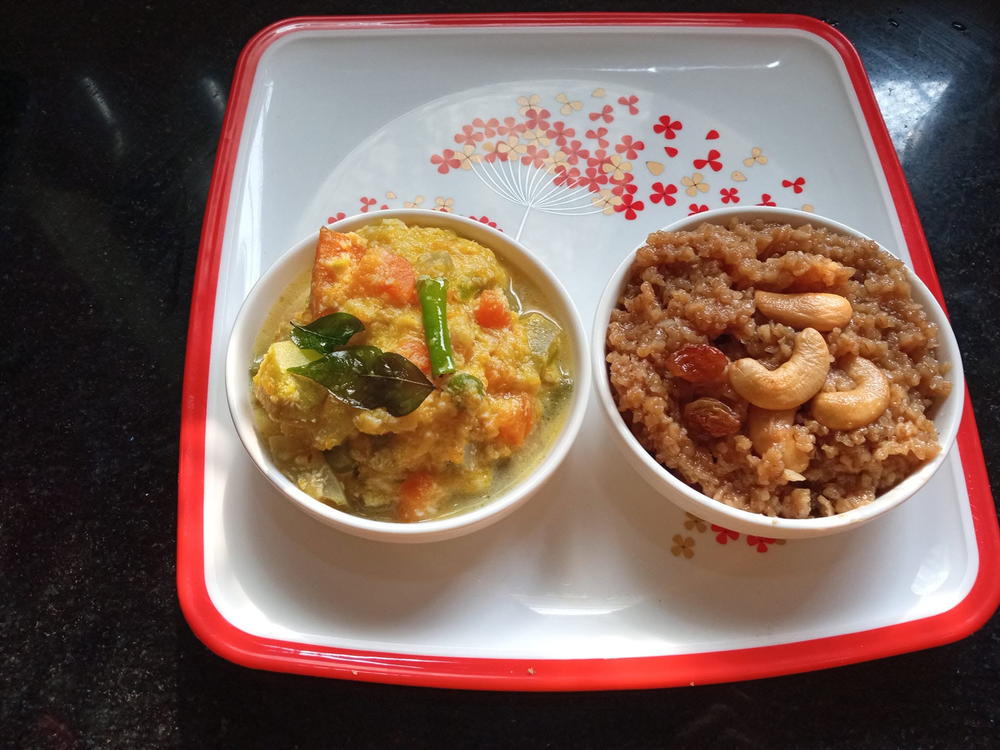 Two bowls of authentic Indian food — avial and halwa — on a red-bordered tray