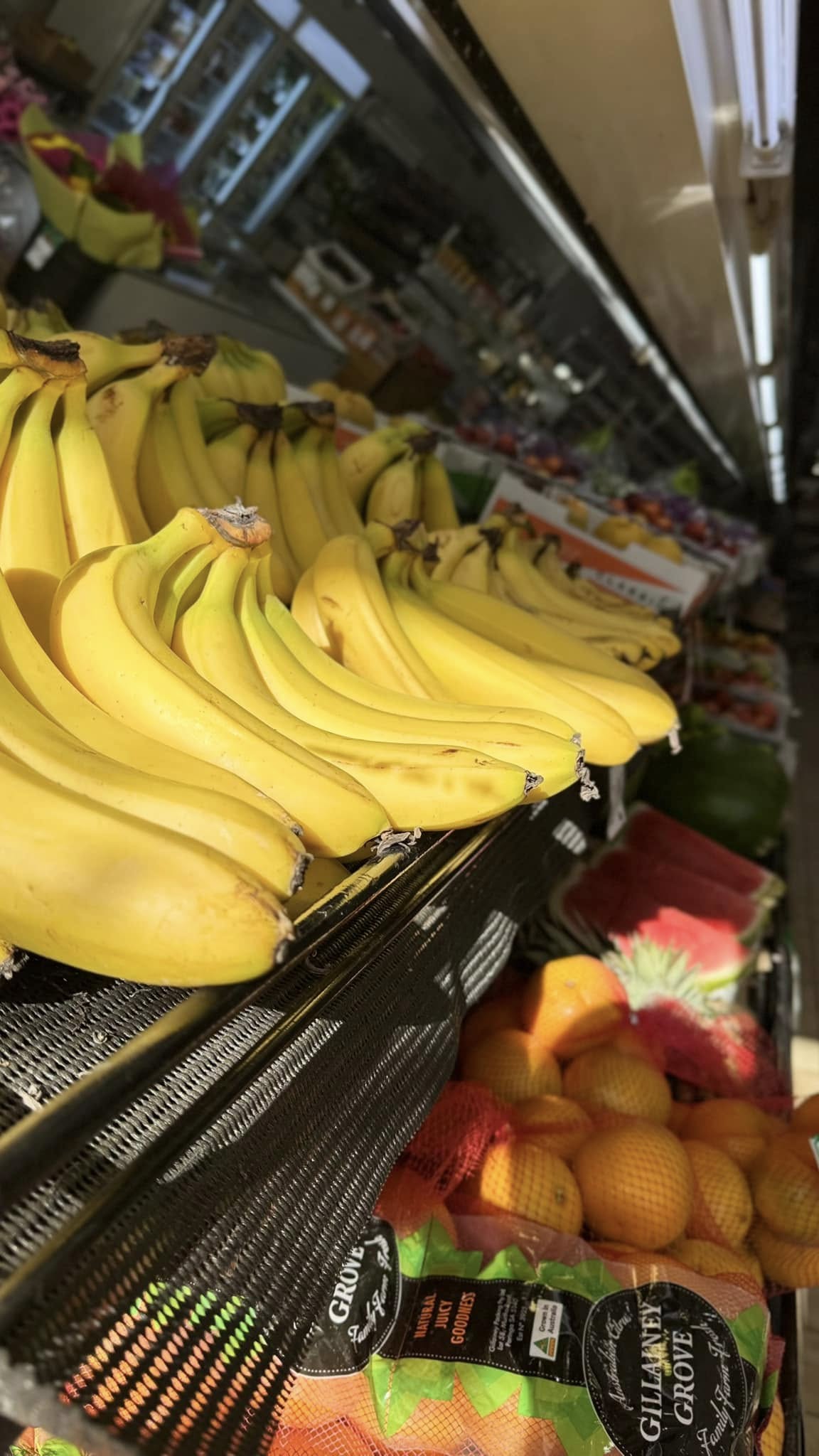 Fresh bananas, oranges and produce on display inside Fawkner Fresh