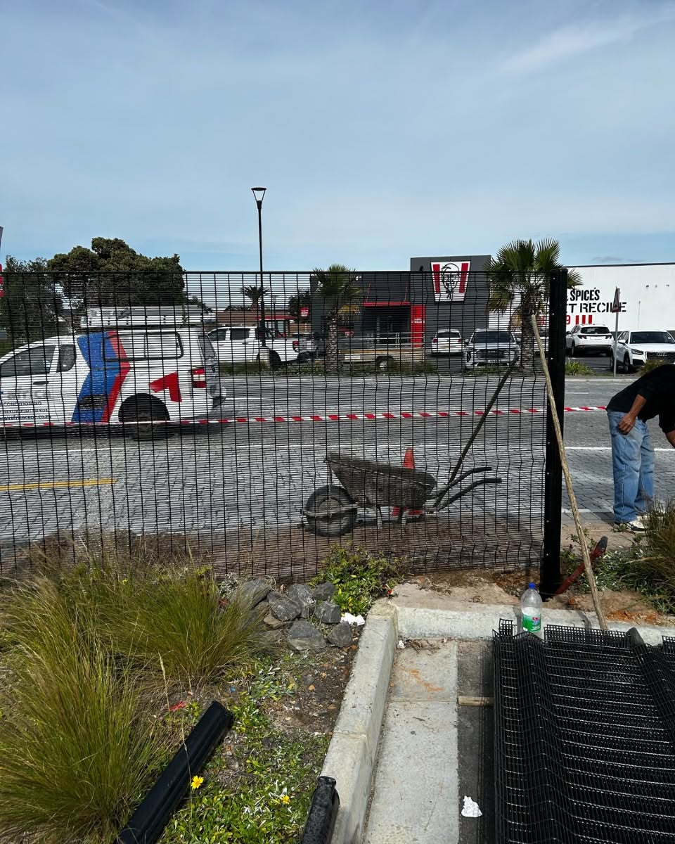 Black steel mesh commercial perimeter fencing installed outside a commercial complex