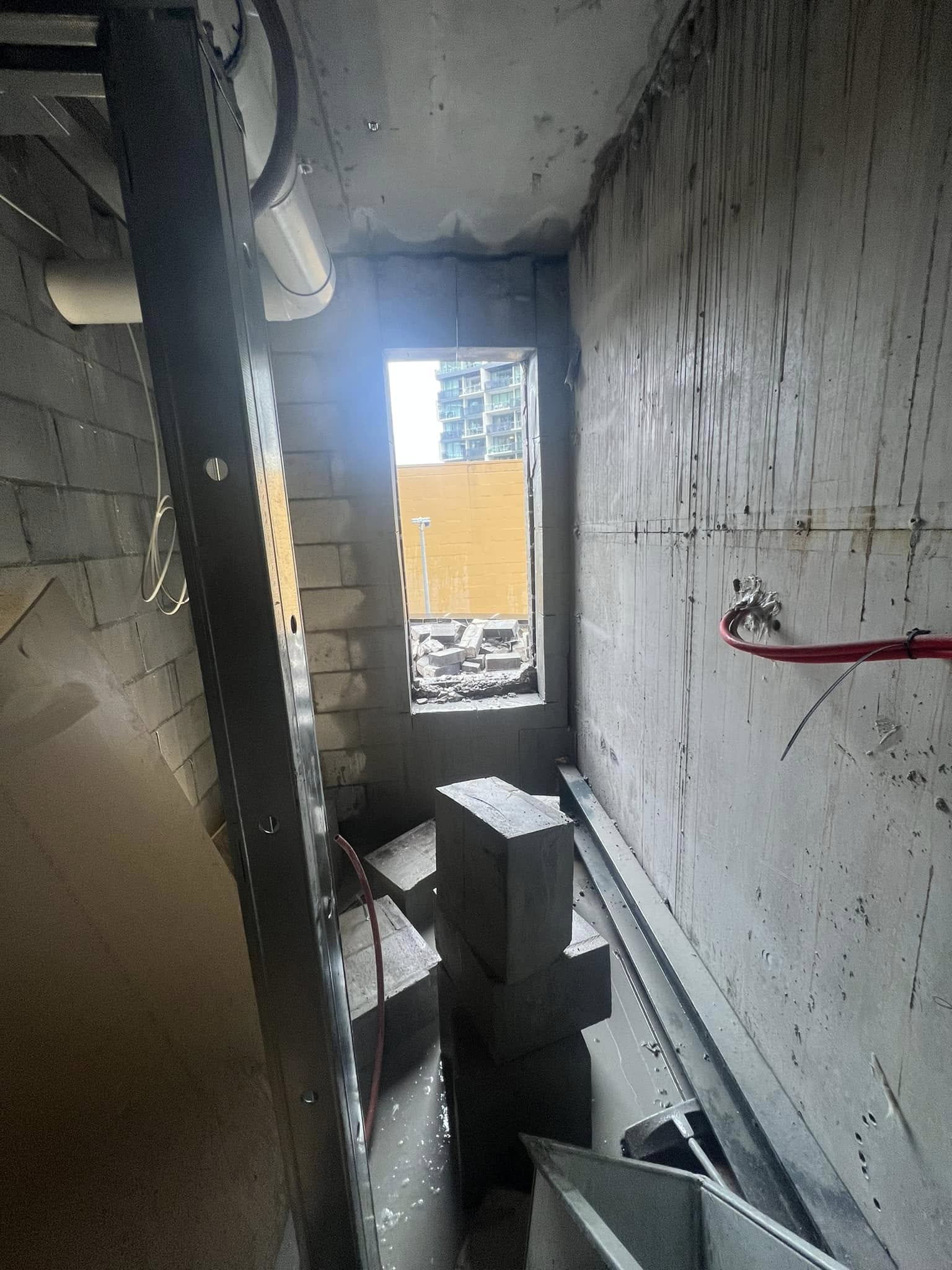 Concrete block wall with fire suppression pipe fitting — result of precision core drilling on a construction site
