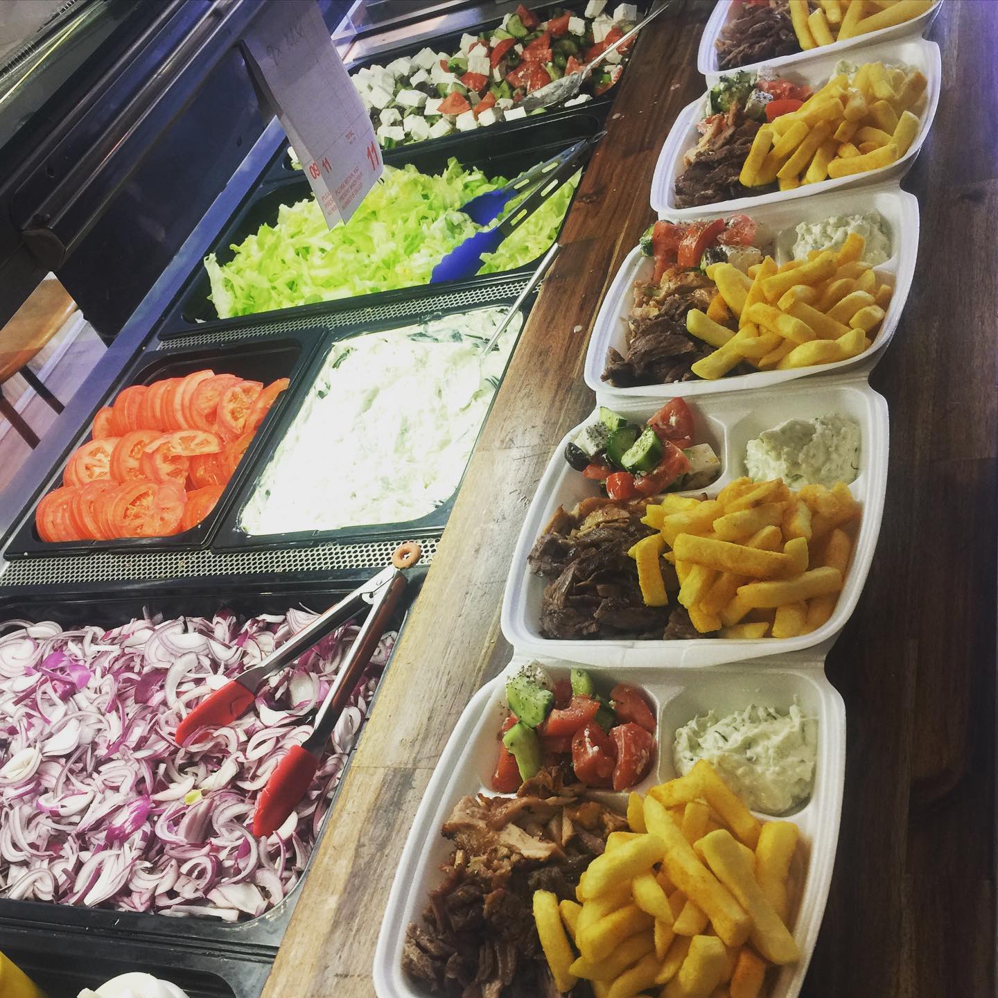 Souvlaki meal platters with fries, Greek salad and tzatziki packed for takeaway