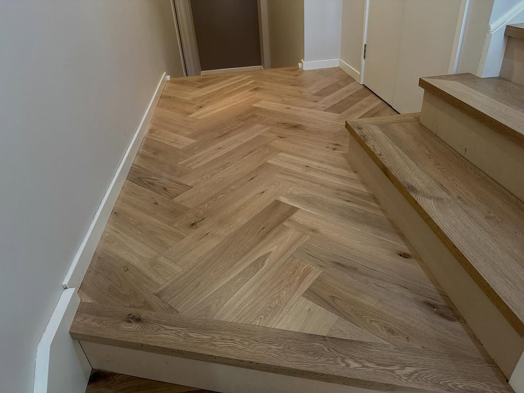 Herringbone oak timber floor at a staircase landing with warm natural grain