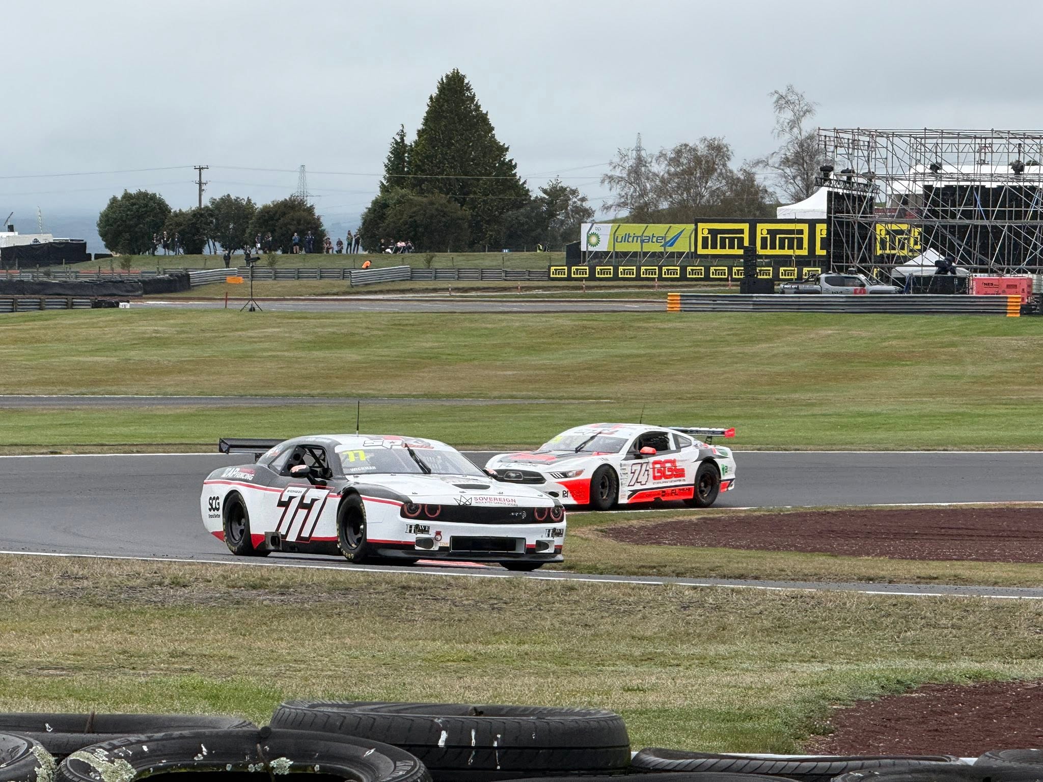 White race car leading another car through a bend