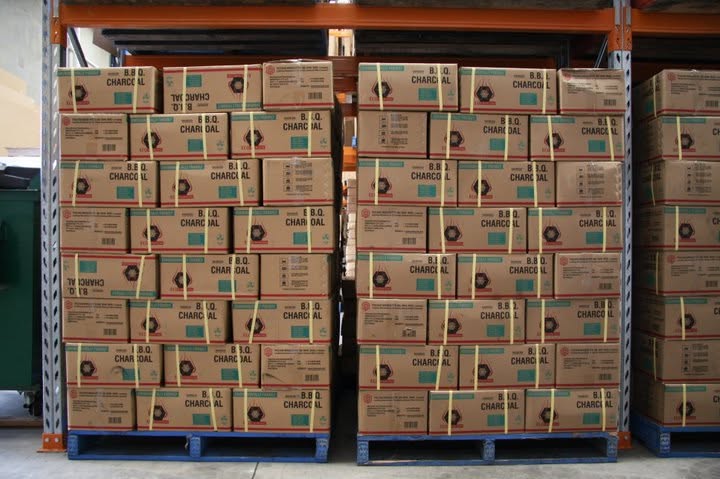 Pallets of BBQ charcoal boxes stacked in the Emberpak warehouse