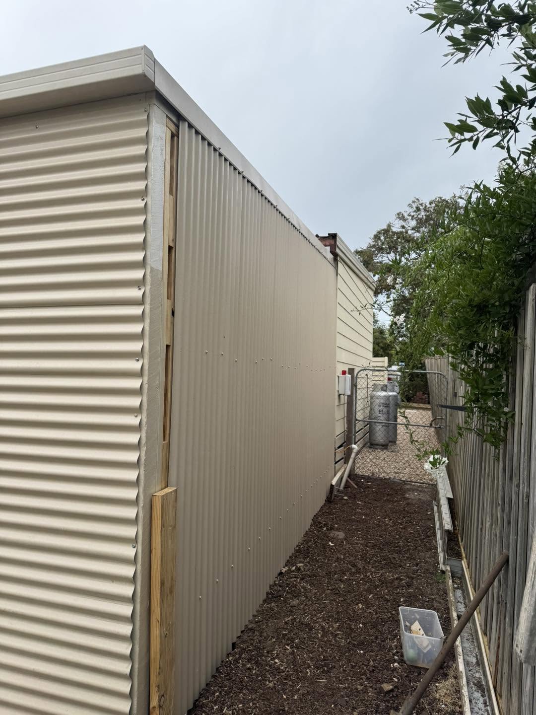Corrugated cladding carpentry installation along a side walkway
