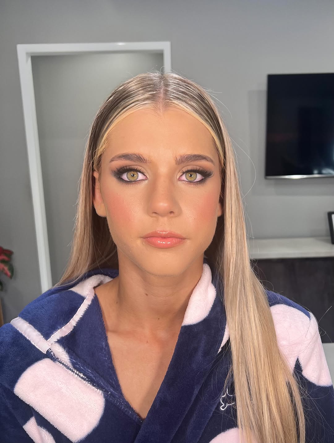 Elegant race day glam makeup look with dramatic eyes and fascinator