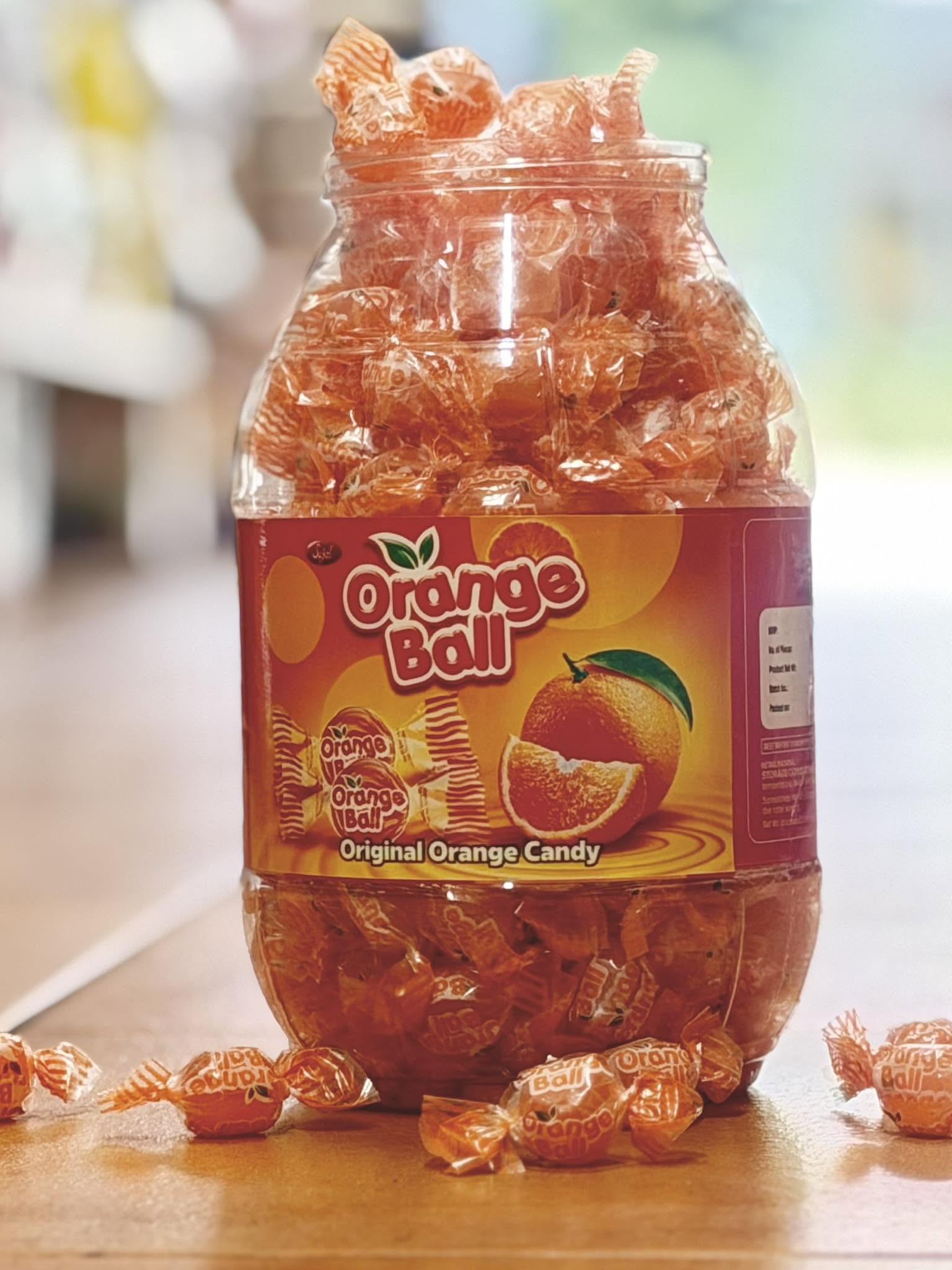 Large jar of Orange Ball original orange candy — South Asian confectionery at Nepalese Indo Bazaar
