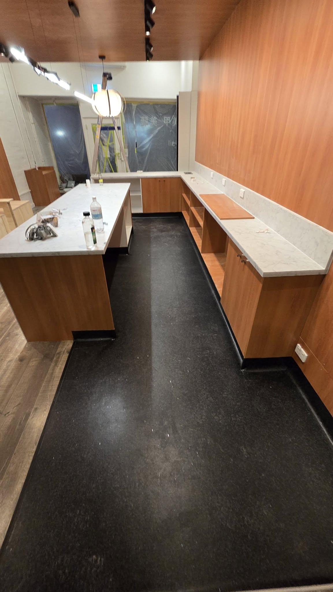 Timber veneer commercial shopfit with stone benchtops under construction