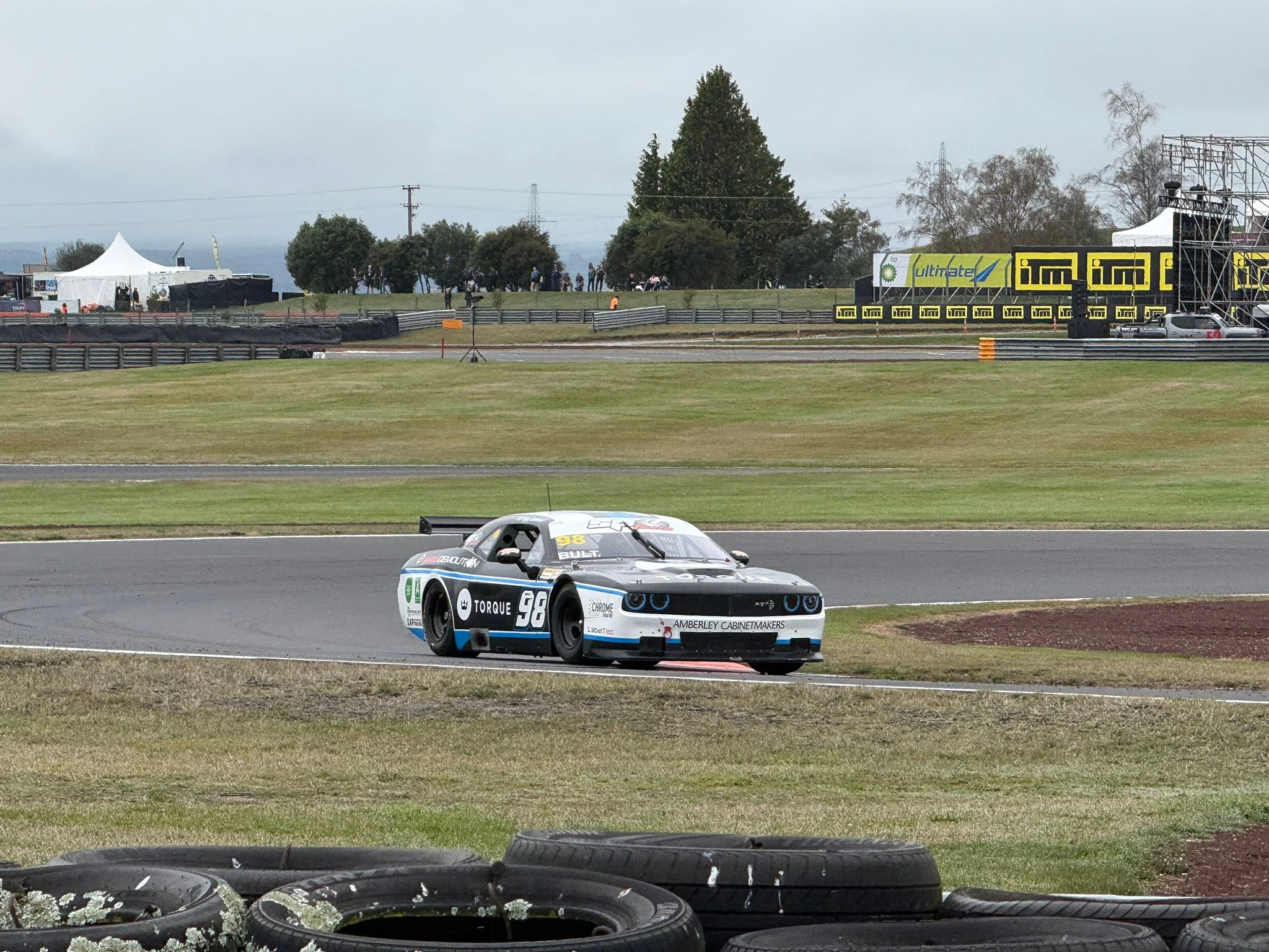 Black and white race car cornering on a wet circuit