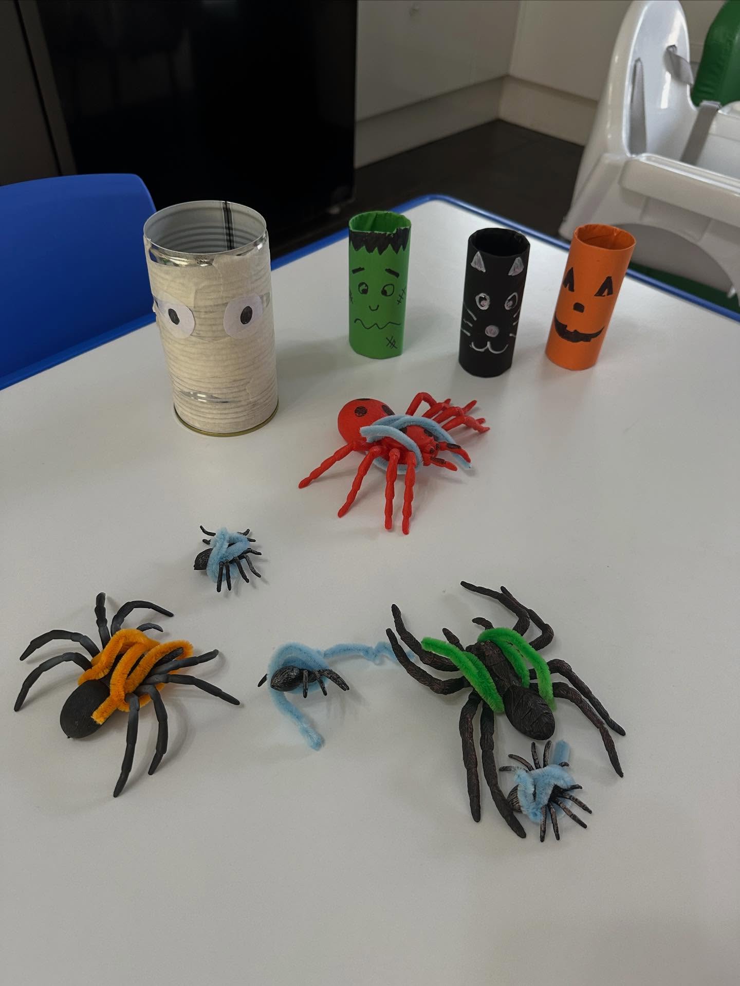 Halloween craft activity featuring handmade spiders and character tubes