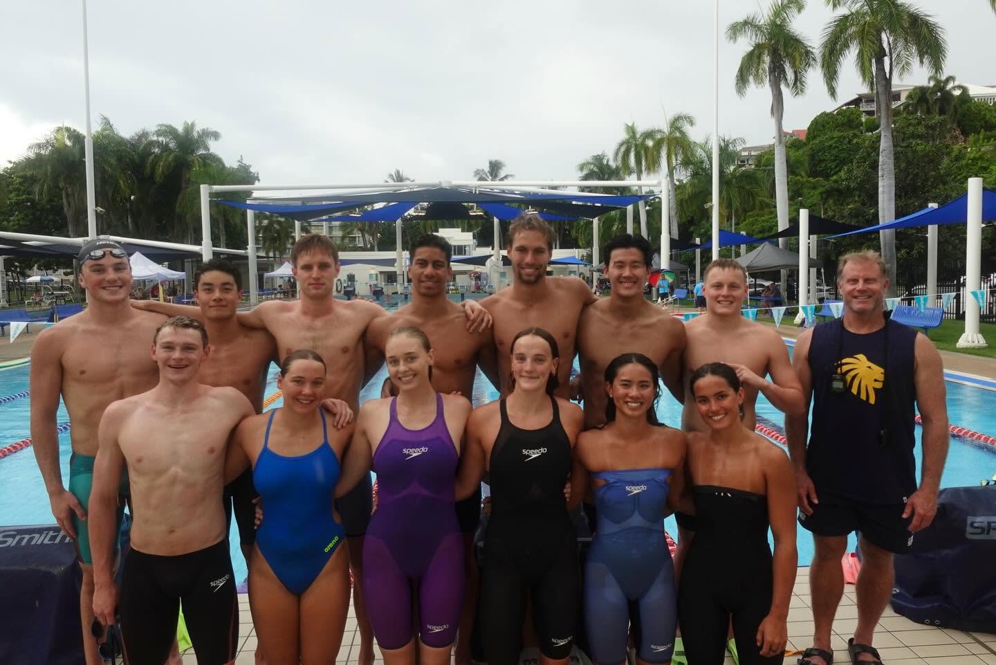 Club swimmers gathered poolside at an outdoor aquatic centre